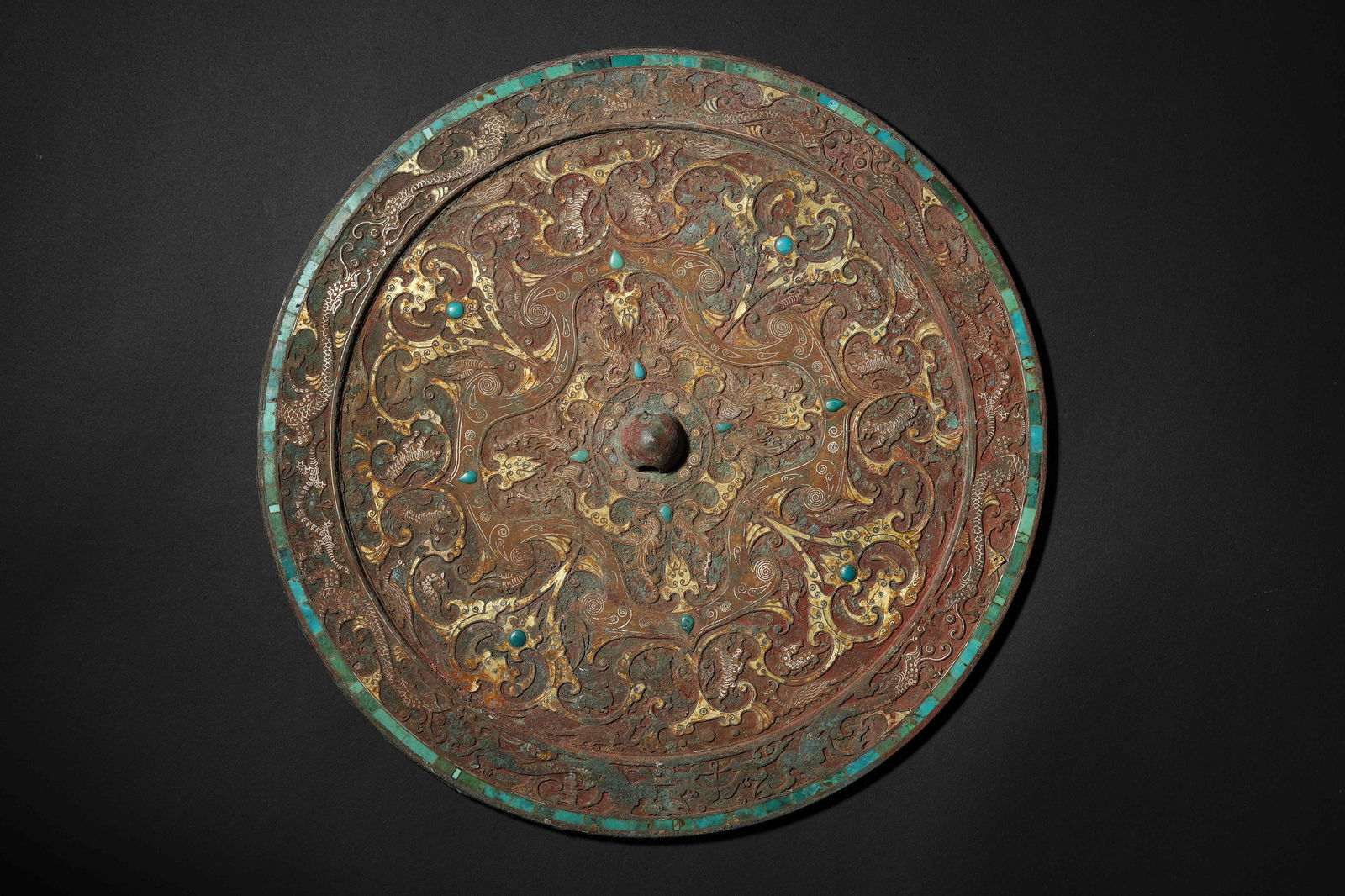 Han Dynasty Gold-and-Silver-Inlaid Turquoise Coiled Dragon-Pattern Bronze Mirror: Diameter 23.0cm (9.06in), Weight 1713.0g (3.78lb)c. 202 BCE-220 CE. Bronze Back with Cuo-Jin & Silver Han Dynasty Mathematical-Style Patterns, Accented with Turquoise Inlays; Turquoise Strip Inlaid at