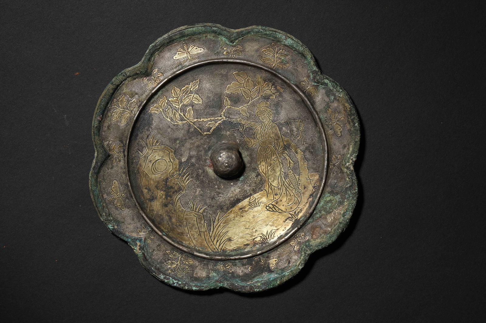 Tang Dynasty Rhombus-Flower Shaped Gold-Inlaid Figure Bronze Mirror: Diameter 14.0cm (5.51in), Weight 643.0g (1.42lb)Inlaid into Diamond-Flower Shape, Cuo-Jin Decorated with Court Ladies, Flowers, Trees & Butterflies; Elegant & Dynamic. A Daily Luxury Vessel of Tang Ar