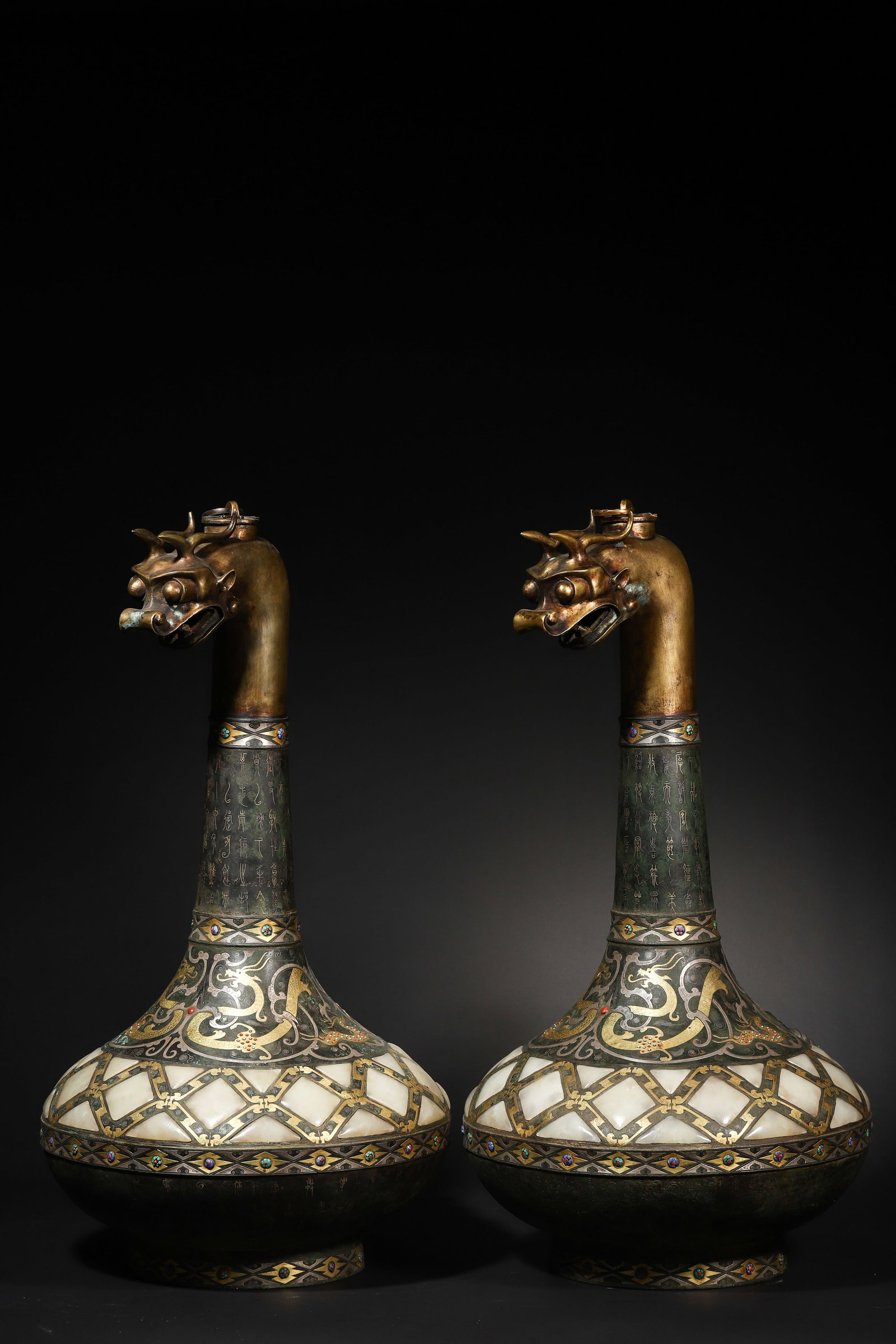 Warring States Period Pair of Gold-and-Silver-Inlaid Jade & Gemstone Dragon-Head Hu (Vessel): Diameter 30.0cm (11.81in), Height 56.0cm (22.05in)c. 475-221 BCE. Vessel body with Cuo-Jin & silver patterns; inlaid with jade & gemstones. Dragon-head lid with long inscriptions. Craftsmanship embodi
