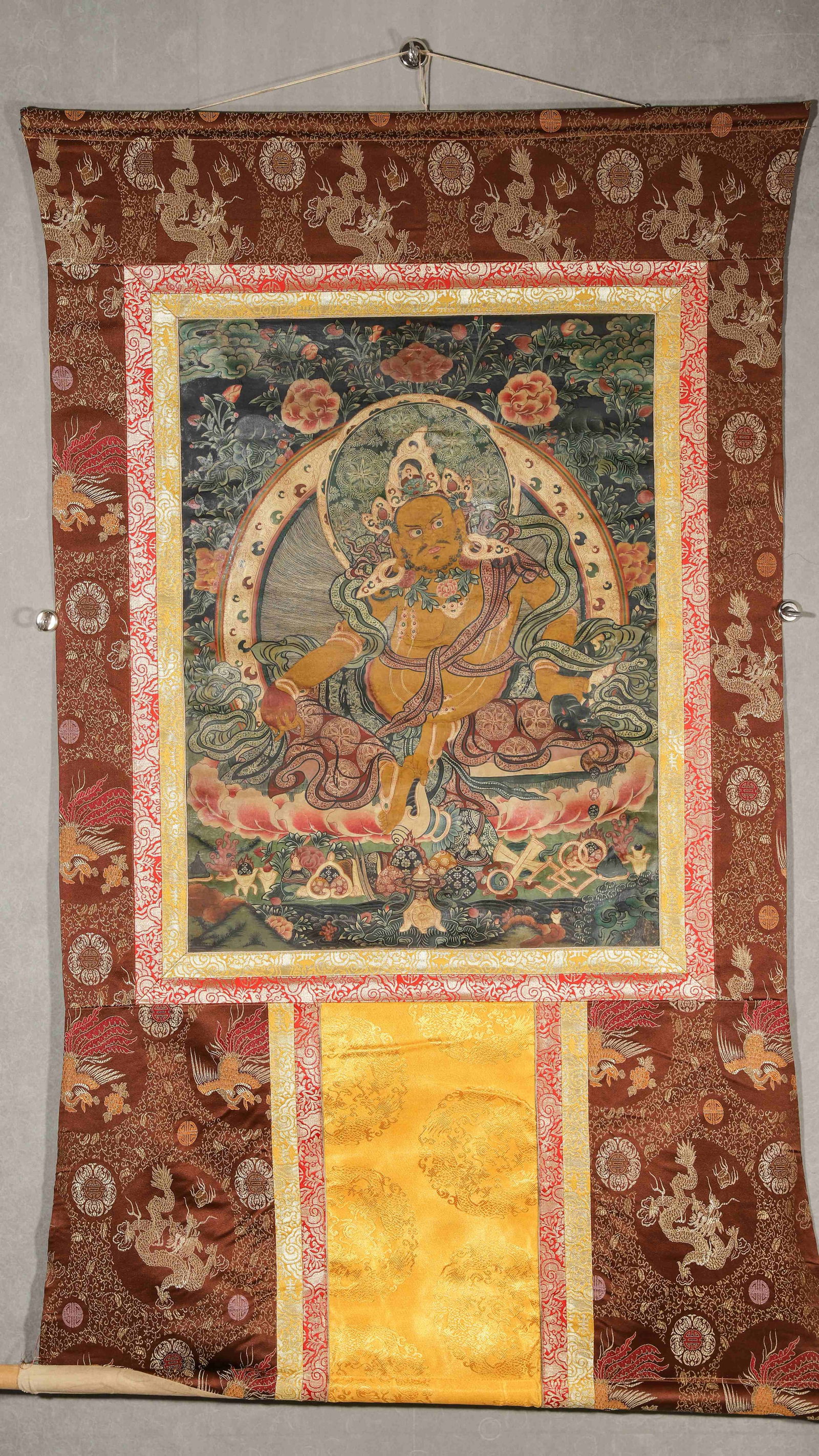 18th Century Tibetan Thangka of Yellow Jambhala: Length 68cm Width 51cm (Length 26.77" Width 20.08")18th-century Wealth God thangka: golden deity (on lotus, with auspicious symbols); solemn, long-lasting mineral pigments. Dragon-pattern brocade
