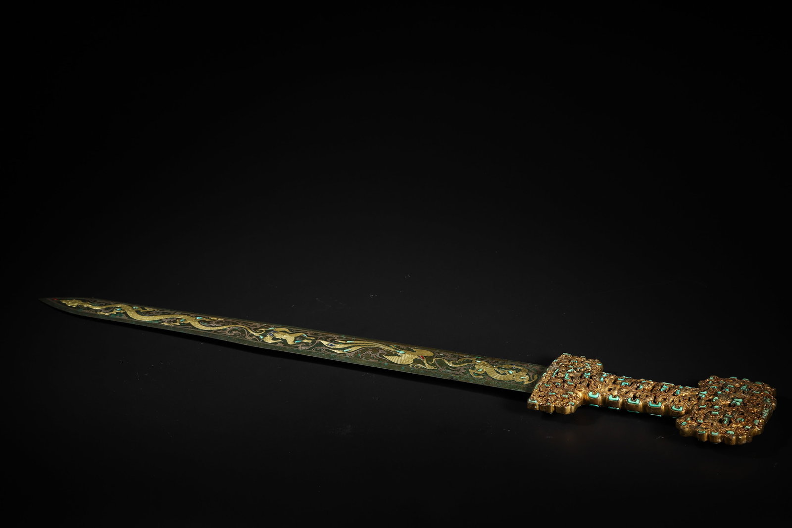 Warring States Period Gold-and-Silver-Inlaid Gemstone Openwork-Hilted Dragon-Phoenix Sword: Length 69.0cm (27.17in), Width 10.0cm (3.94in), Weight 1356.0g (2.99lb)c. 475-221 BCE. Sword tang with openwork Cuo-Jin & turquoise inlay; blade with Cuo-Jin dragon-phoenix & auspicious beast patterns