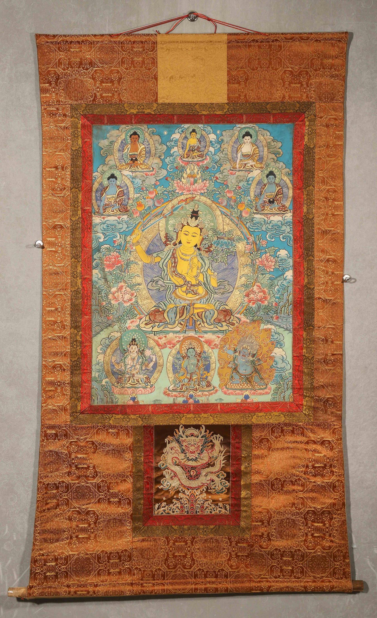 Mid-Qing Dynasty, Mineral Pigment Thangka of Manjusri Bodhisattva: Length (L): 80.0cm (31.5in); Width (W): 57.0cm (22.44in)This mid-Qing Dynasty thangka depicts Manjusri Bodhisattva with natural mineral pigments, featuring exquisite craftsmanship, rich colors, and