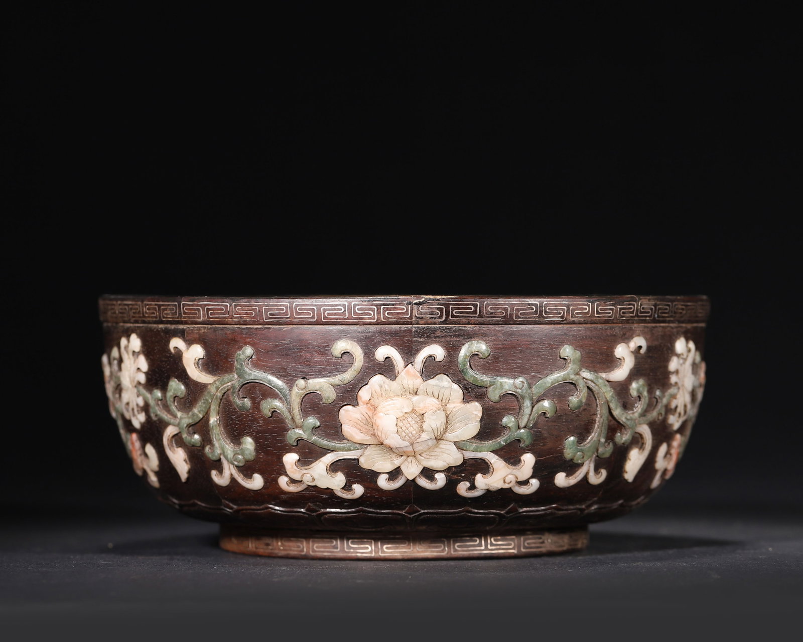 A Large Zitanwood Bowl with Inlaid Precious Stones, Qianlong Period, Qing Dynasty: Diameter (Dia): 18.0cm (7.09in); Height (H): 7.5cm (2.95in); Weight (Wt): 452.0g (1.0lb)This imperial bowl, made during the Qianlong period, features zitanwood inlaid with mother-of-pearl, jadeite