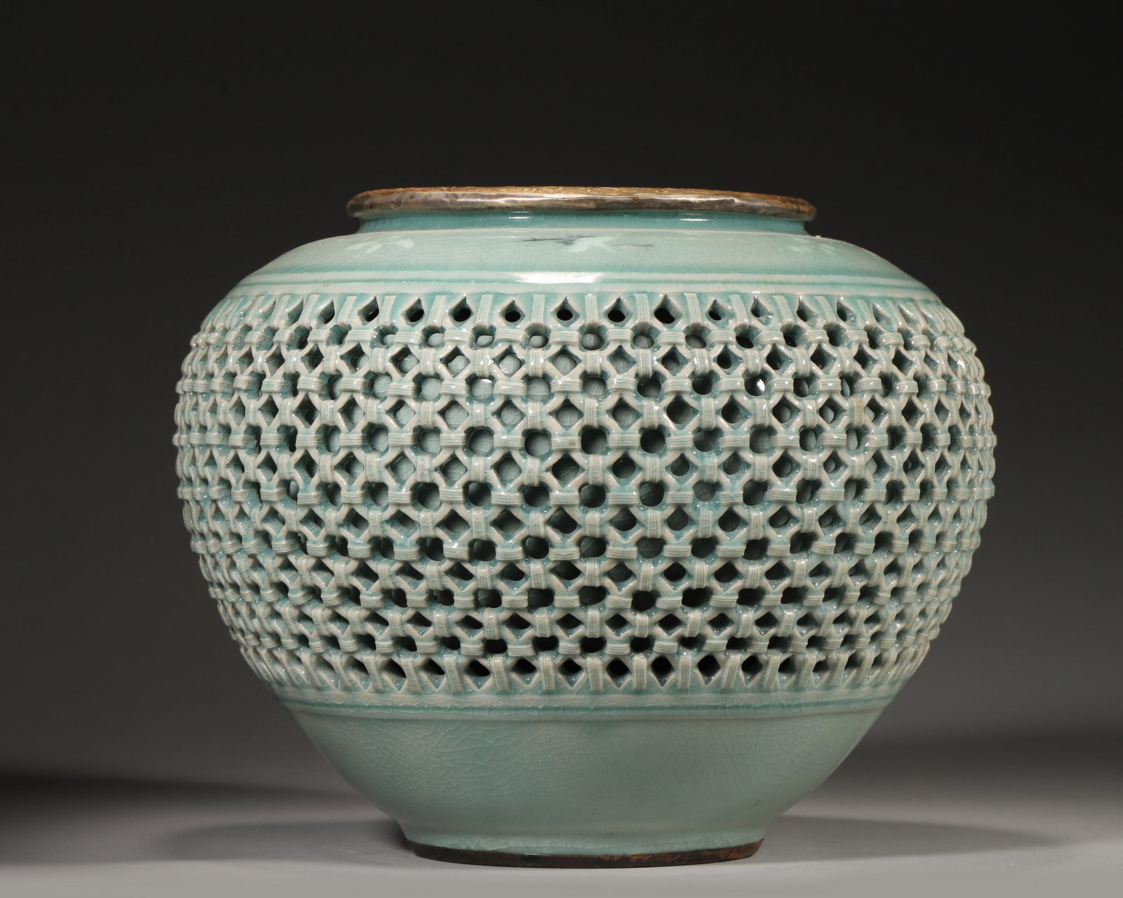 Song Dynasty Longquan Kiln Celadon Reticulated Gilt Jar: Diameter (Dia): 24.0cm (9.45in); Height (H): 18.0cm (7.09in)A precious Song Dynasty Longquan Kiln jar with pale celadon crackled glaze, full-body reticulated bamboo-weave pattern, gilt floral rim,