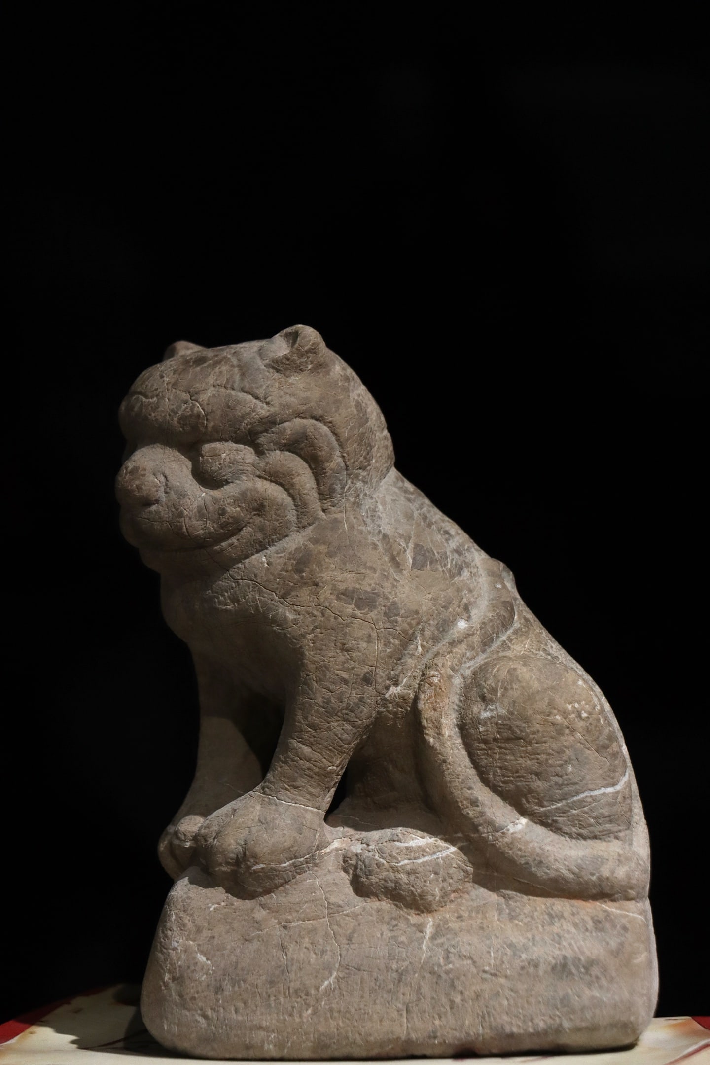 A FINE STONE FIGURE OF AN AUSPICIOUS BEAST, TANG DYNASTY: Height: 9.06" inches (23.0 cm)This fine stone figure of an auspicious beast, from the Tang Dynasty (7th–9th century AD), is carved from grey stone. The beast sits proudly, with simple and powerful l