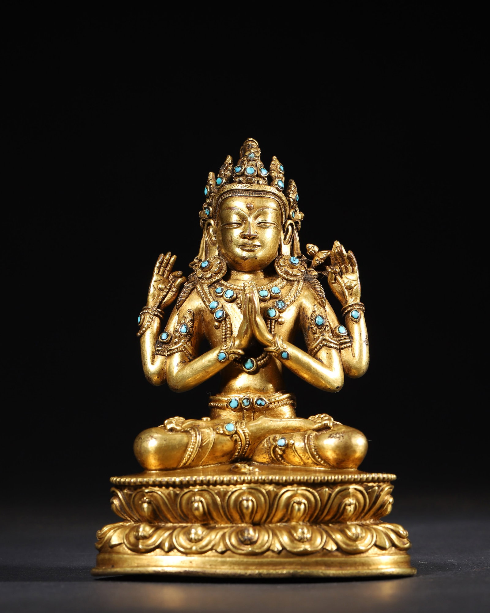 AN GILT-BRONZE FIGURE OF FOUR-ARMED AVALOKITESHVARA INLAID WITH TURQUOISE, MING DYNASTY: 4.13" x 2.95" x 6.69" inches (10.5 cm x 7.5 cm x 17.0 cm) | Weight: 1.95 lbs (883.0 g)An masterpiece, this seated figure of Four-Armed Avalokiteshvara is exquisitely cast in gilt-bronze and inlaid wit