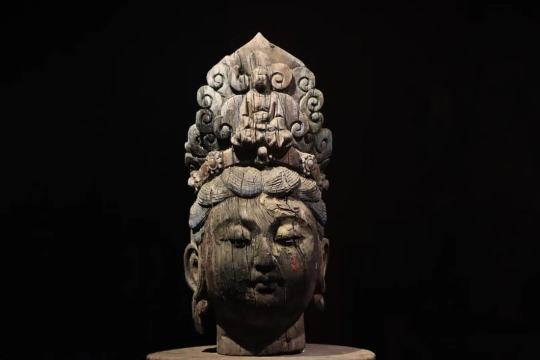 A FINE POLYCHROMED WOOD HEAD OF GUANYIN, MING DYNASTY, 14TH–17TH CENTURY AD: Height: 21.65" inches (55.0 cm) | Width: 9.84" inches (25.0 cm)This is the head of a Guanyin (Bodhisattva of Compassion) sculpture, featuring an exquisitely carved face with a serene, compassionate co