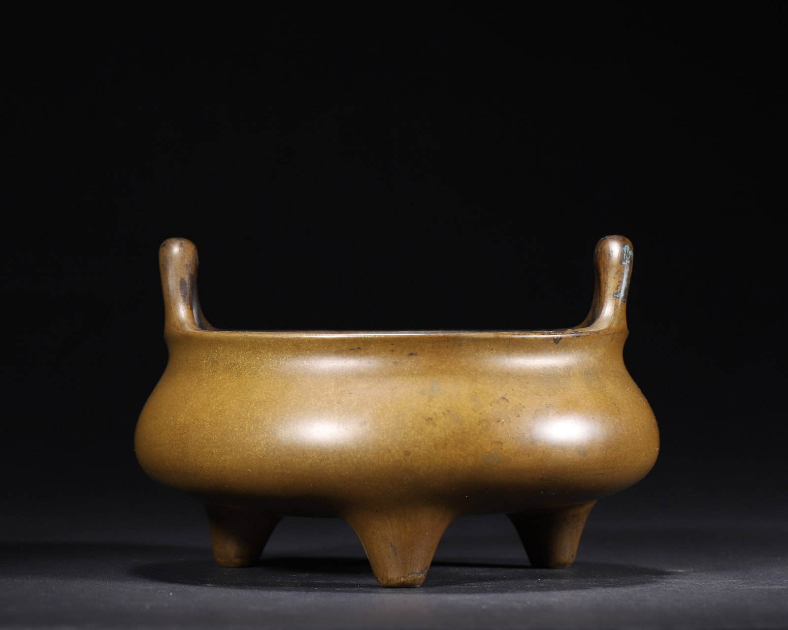 KANGXI PERIOD, QING DYNASTY: A BRONZE TRIPOD CENSER WITH FLARING HANDLES AND "KANGXI" MARK: 6.3" x 3.94" inches (16.0 cm x 10.0 cm) | Weight: 2.72 lbs (1234.0 g)A fine Kangxi-period bronze tripod censer with elegant flaring handles, a rounded body, and a rich eel-skin patina. The base bears