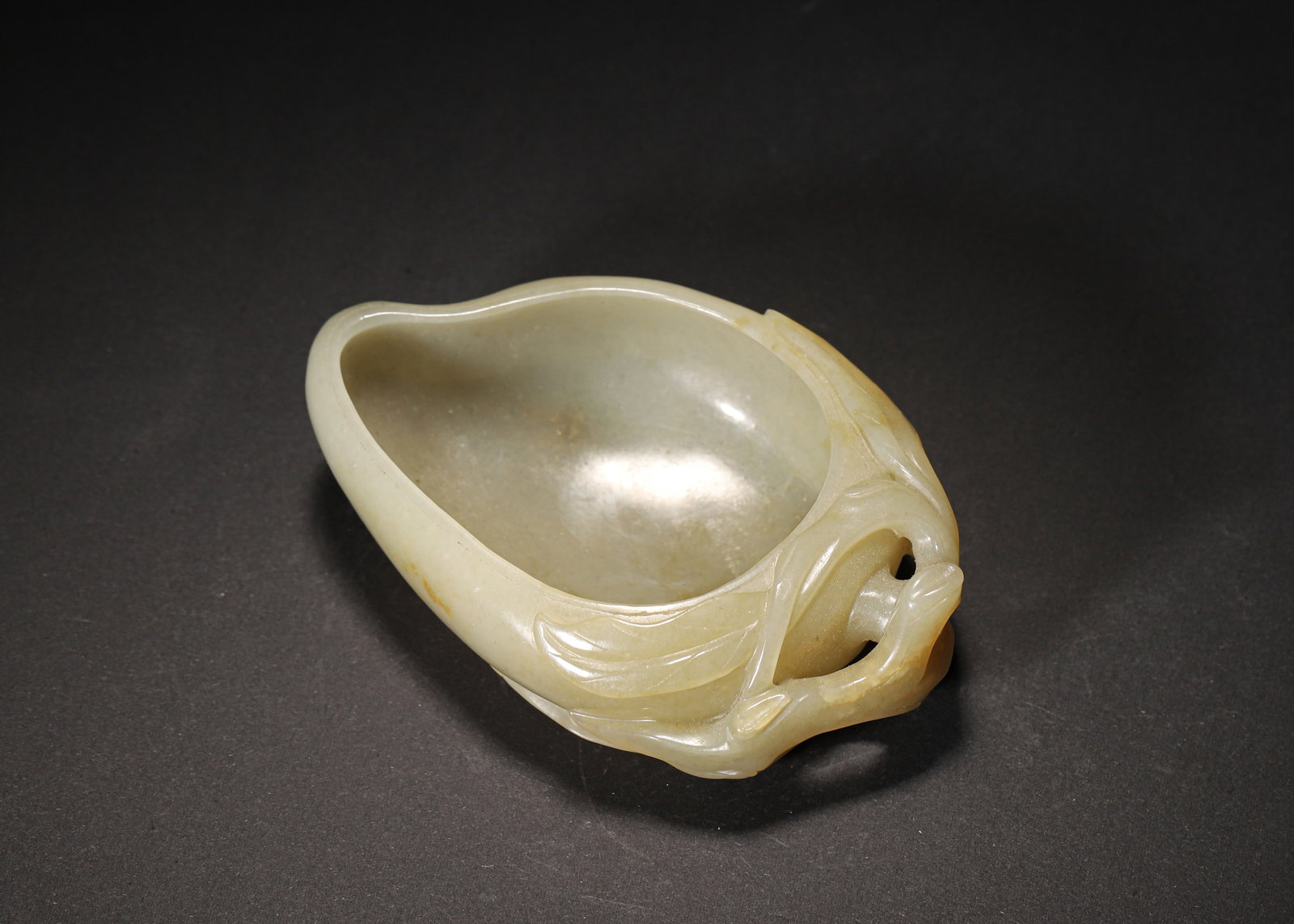 MID-QING DYNASTY, CELADON-WHITE HETIAN JADE PEACH-FORM WATER COUPE: 3.88" x 2.50" (1.0cm x 6.5cm) | 0.24lbCarved from a single piece of celadon-white Hetian jade, this mid-Qing Dynasty water coupe features a plump peach form with delicate relief carvings of leaves and