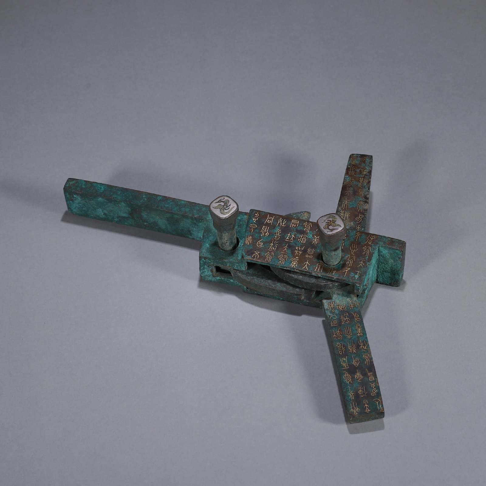 AN IMPORTANT ARCHAIC BRONZE CROSSBOW MECHANISM (NU JI) WITH GOLD AND SILVER INLAY, MIDDLE TO LATE: L:21cm (8.27 in) W:7.5cm (2.95 in) WT:1020gA fine archaic bronze crossbow mechanism (nu ji), Middle to Late Warring States period, with gold and silver inlaid inscriptions and animal motifs, of excell
