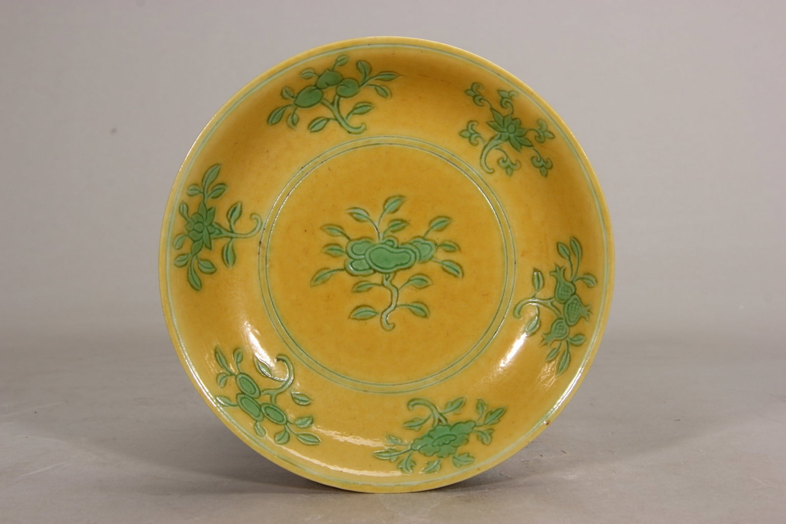 MING JIAJING: YELLOW-GROUND GREEN-ENAMEL SAUCER WITH FLORAL MOTIF (1 of 9)