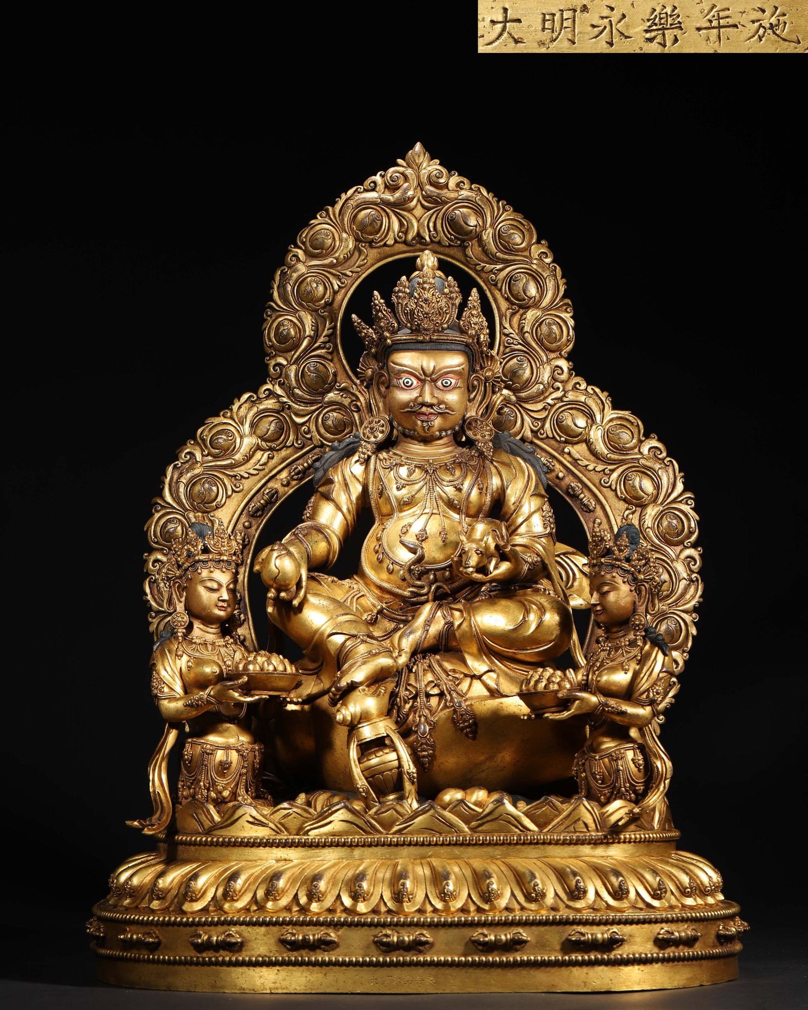 IMPERIAL GILT-BRONZE STATUE OF JAMBHALA WITH TWO OFFERING GODDESSES, YONGLE PERIOD, MING DYNASTY: 14.96" x 10.24" x 20.08" inches (38.0 cm x 26.0 cm x 51.0 cm) (Main) | Weight: 55.78 lbs (25300.0 g)An imperial gilt-bronze statue of Jambhala with two offering goddesses, made in the Yongle period of