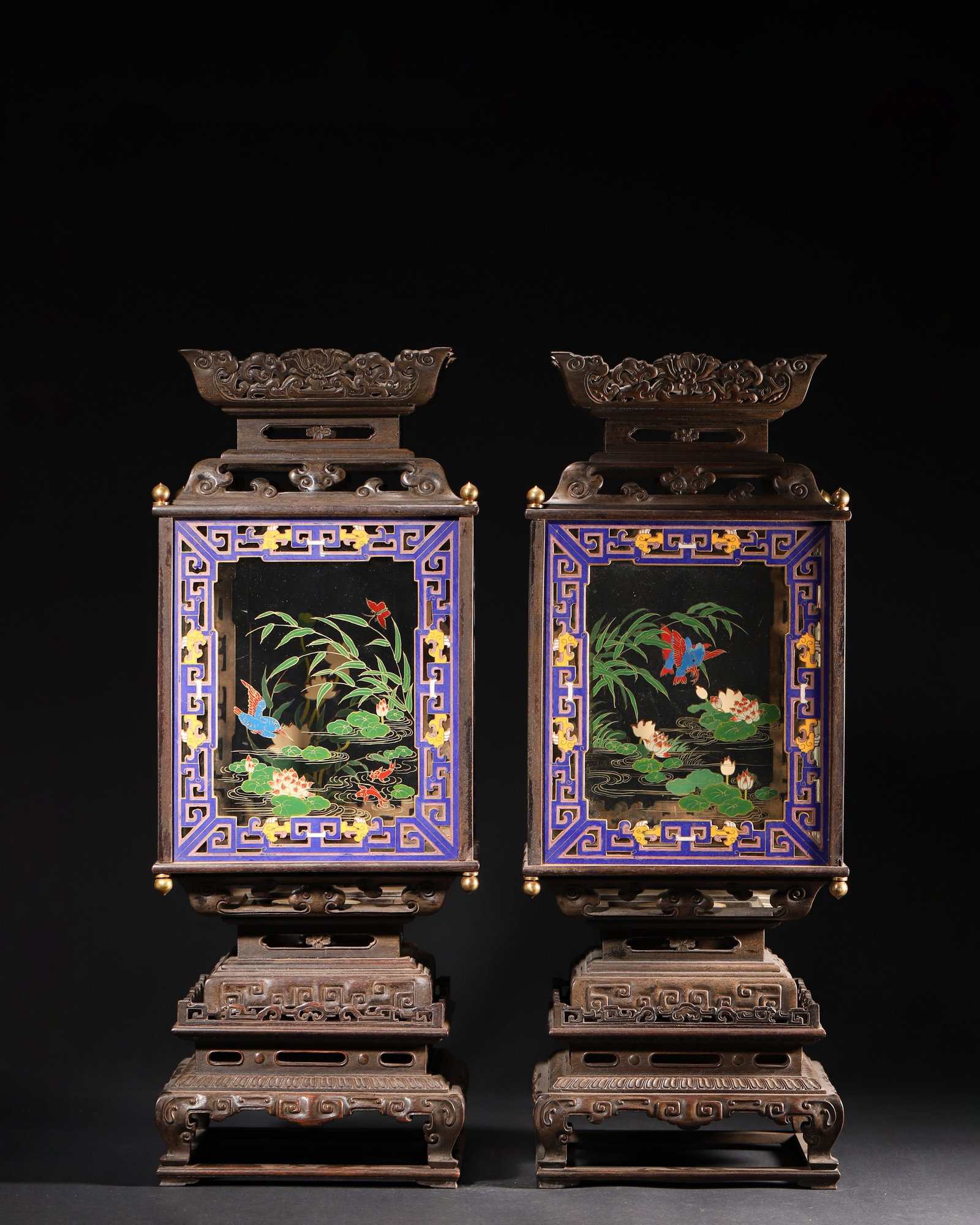 A PAIR OF ZITAN WOOD PALACE LANTERNS WITH ENAMEL AND PAINTED GLASS PANELS, QIANLONG PERIOD, QING: 7.88" x 7.88" x 20.12" (2.0cm x 2.0cm x 51.0cm) | 15.87lbThis pair of palace lanterns features zitan wood frames, enamel inlays, and glass panels painted with lotus pond scenes. Exquisitely crafted, t