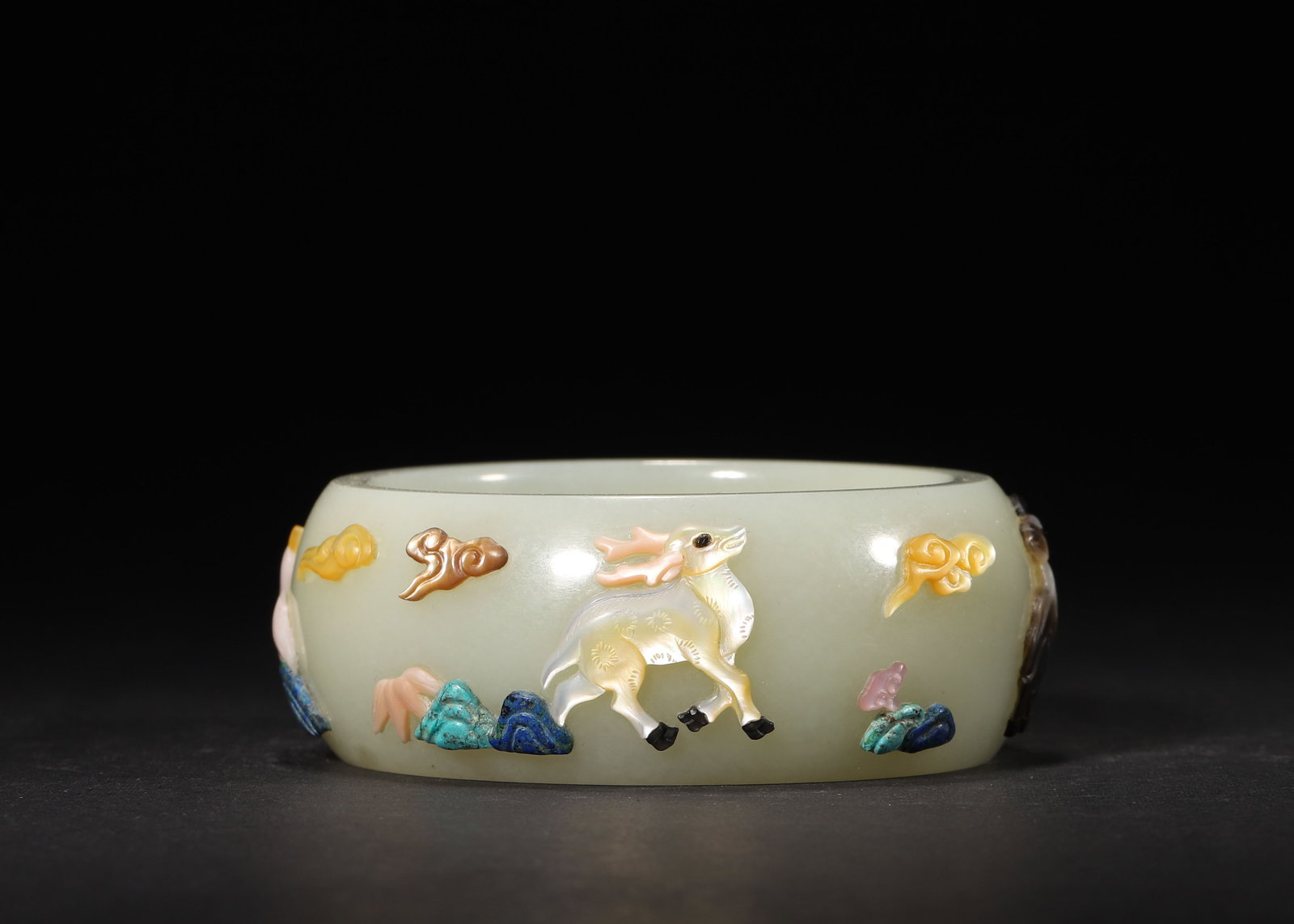 MID-QING DYNASTY, WHITE HETIAN JADE BANGLE WITH HUNDRED TREASURES INLAY OF FORTUNE, PROSPERITY AND: Inner D 2.25" (Inner D 5.8cm) | 0.32lbCrafted from white Hetian jade, this mid-Qing bangle features a wide, warm band with elaborate "hundred treasures" inlay depicting deer, pines and clouds, symboli