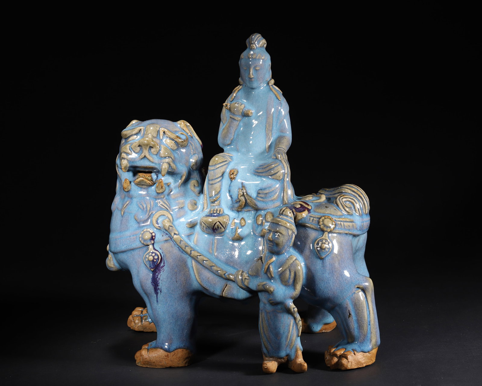 JIN TO YUAN DYNASTY: A JUNYAO SKY-BLUE GLAZED FIGURE OF MANJUSHRI ON A LION WITH RED SPLASHES: 12.6" x 7.87" x 13.78" inches (32.0 cm x 20.0 cm x 35.0 cm) (Main)A precious Buddhist statue from Jin to Yuan Dynasty. Manjushri sits serenely on a lion, led by a Hu figure. The sky-blue glaze is lust