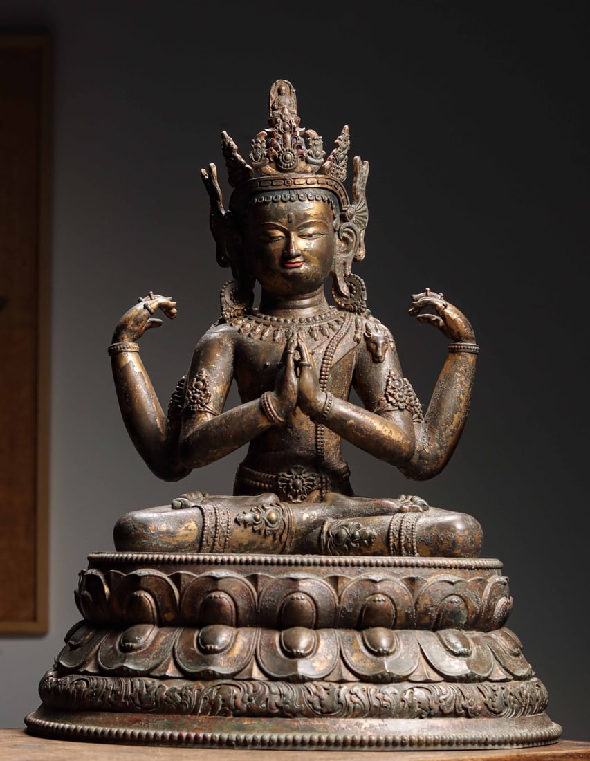 MING DYNASTY, GILT BRONZE SEATED FOUR-ARMED GUANYIN: Weight: 17050g (37.59 lb) | H: 62cm (24.41 in) | W: 46cm (18.11 in) | D: 39cm (15.35 in)A fine gilt bronze figure of Four-Armed Guanyin from the mid Ming Dynasty, blending Han and Tibetan styles. With