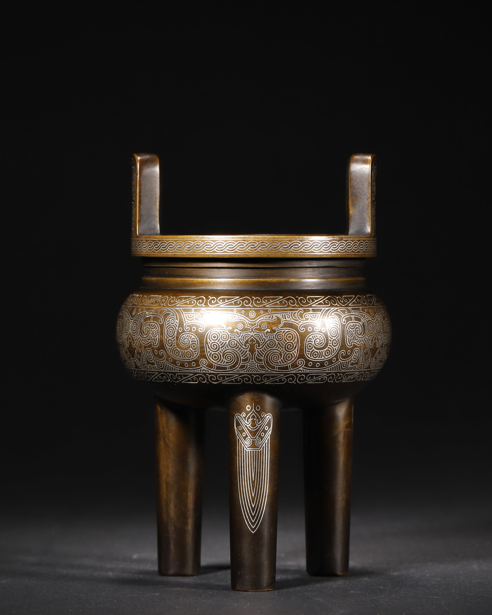QING DYNASTY, 17-19TH CENTURY SILVER-INLAID BRONZE TRIPOD CENSER (MARKED "SHISOU"): D 3.50" x H 5.88" (D 9.0cm x H 15.0cm) | 2.52lbThis censer, modeled after a Shang and Zhou dynasty ding, is made of fine bronze with all-over silver inlaid dragon patterns. The clear "Shisou" mark at