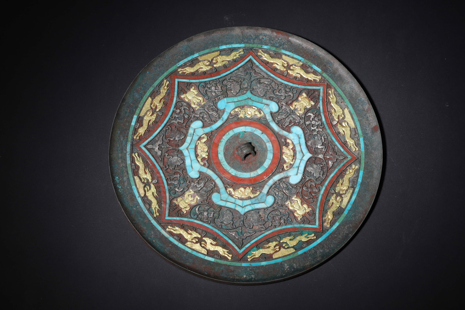 WARRING STATES PERIOD BRONZE MIRROR WITH GOLD AND SILVER INLAY, TURQUOISE INLAYS, AND DIVINE BEAST: 9.06" inches (23.0 cm) | Weight: 2.99 lbs (1355.0 g)An aristocratic mirror from the Warring States Period, featuring a bronze surface decorated with gold and silver inlay, turquoise inlays, and divine