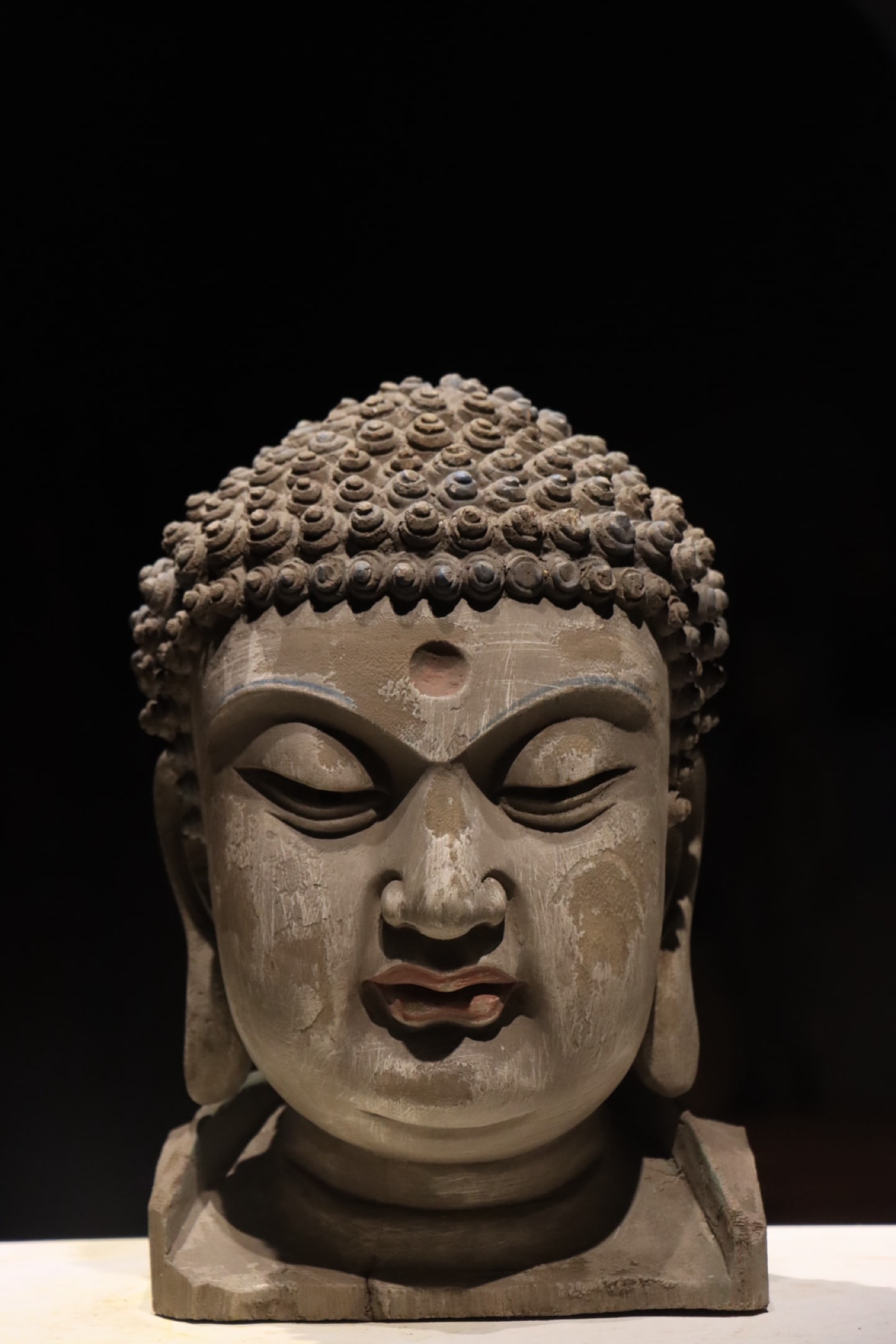 SONG DYNASTY (11TH-13TH CENTURY) POLYCHROME WOOD-CARVED HEAD OF SHAKYAMUNI BUDDHA: Height: 13.78" inches (35.0 cm)This Song Dynasty polychrome wood Buddha head is a top-tier Han Buddhist artwork. It features a serene compassionate face, exquisite carving, aged mineral pigments, and