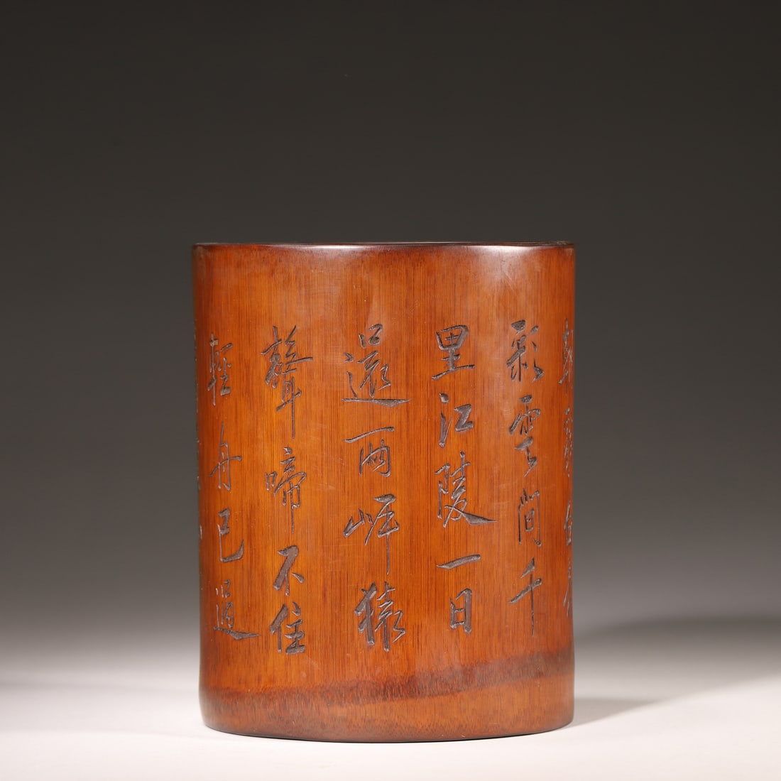 A Bamboo Carved Brush Pot with "Departing from Baidi City at Dawn" Poem Inscription, Qing Dynasty: D 13.0cm (5.12 in); H 17.0cm (6.69 in); Wt 469.0g (1.03 lb)This brush pot is carved from a whole bamboo segment, with a straight, regular shape and a warm chestnut patina revealing its age. Its exteri