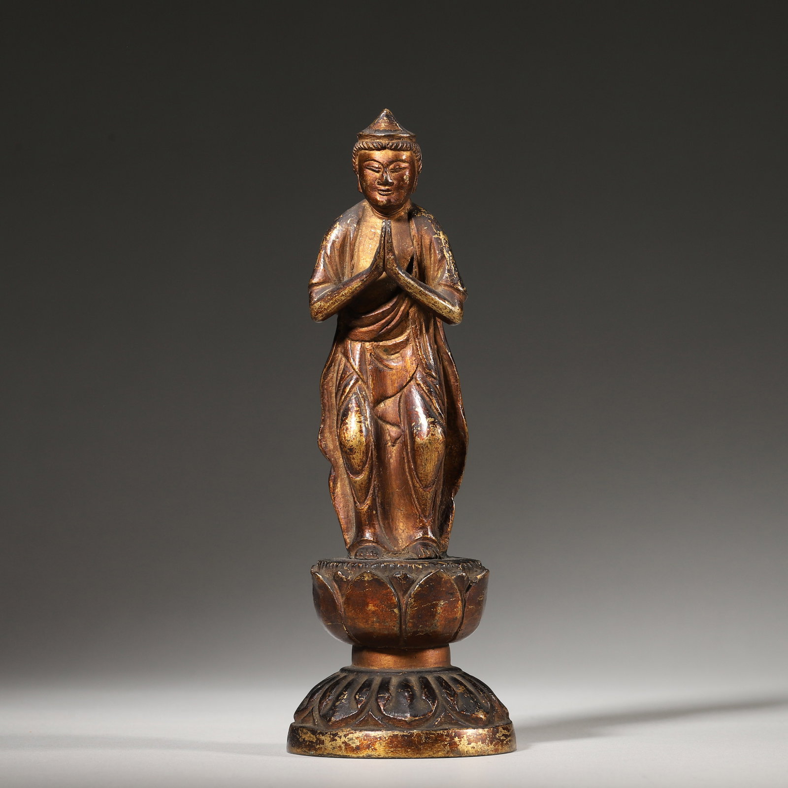 A Lacquered and Gilt Bronze Standing Bodhisattva, Ming Dynasty: L 6.0cm (2.36 in); W 5.0cm (1.97 in); H 18.0cm (7.09 in); Wt 376.0g (0.83 lb)This standing bodhisattva is cast in bronze and lacquered-gilt, in a praying pose atop a double lotus pedestal. With serene