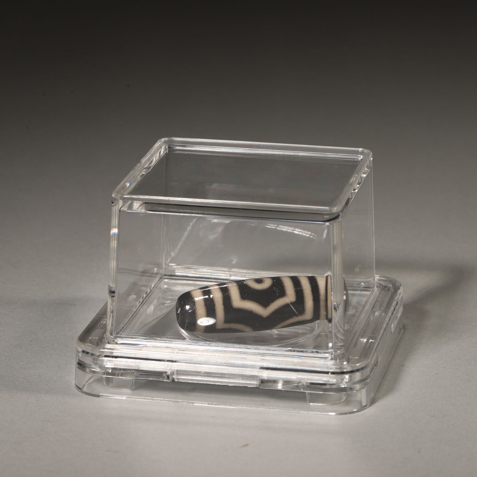 A Tibetan Three-Eye Agate Dzi Bead, Yuan Dynasty: D 3.78cm (1.49 in); Wt 8.5g (0.02 lb)This three-eye dzi bead is a traditional Yuan Dynasty Tibetan ritual object, crafted from agate with rich patina and clear patterns. It is a well-preserved and aus
