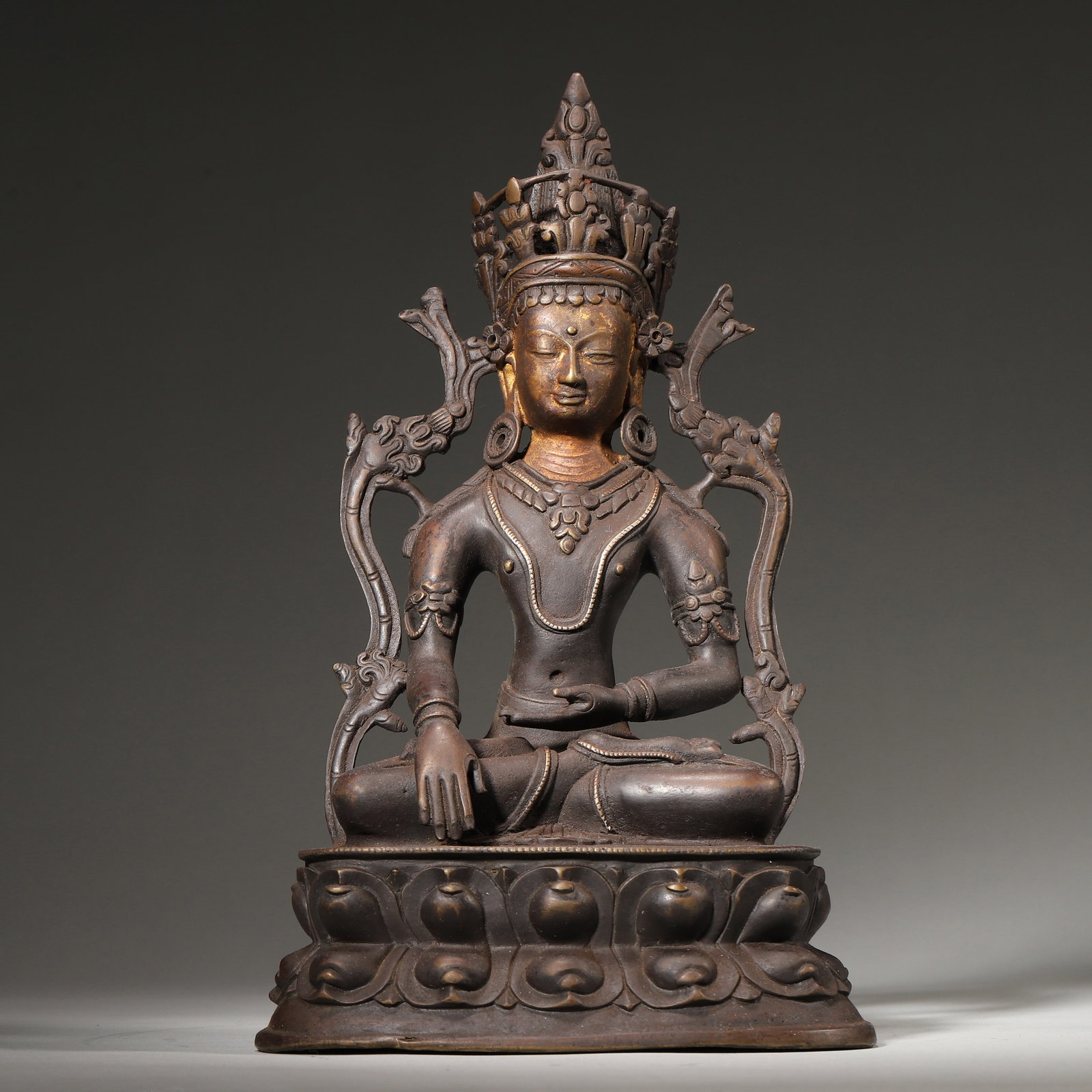 A Partial Gilt Copper Buddha Statue, Ladakh Style, 15th Century: L 15.0cm (5.91 in); W 9.5cm (3.74 in); H 25.0cm (9.84 in); Wt 1532.0g (3.38 lb)A partial gilt copper Buddha statue in Ladakh style, 15th century. Seated in padmasana on a double lotus throne, the Budd
