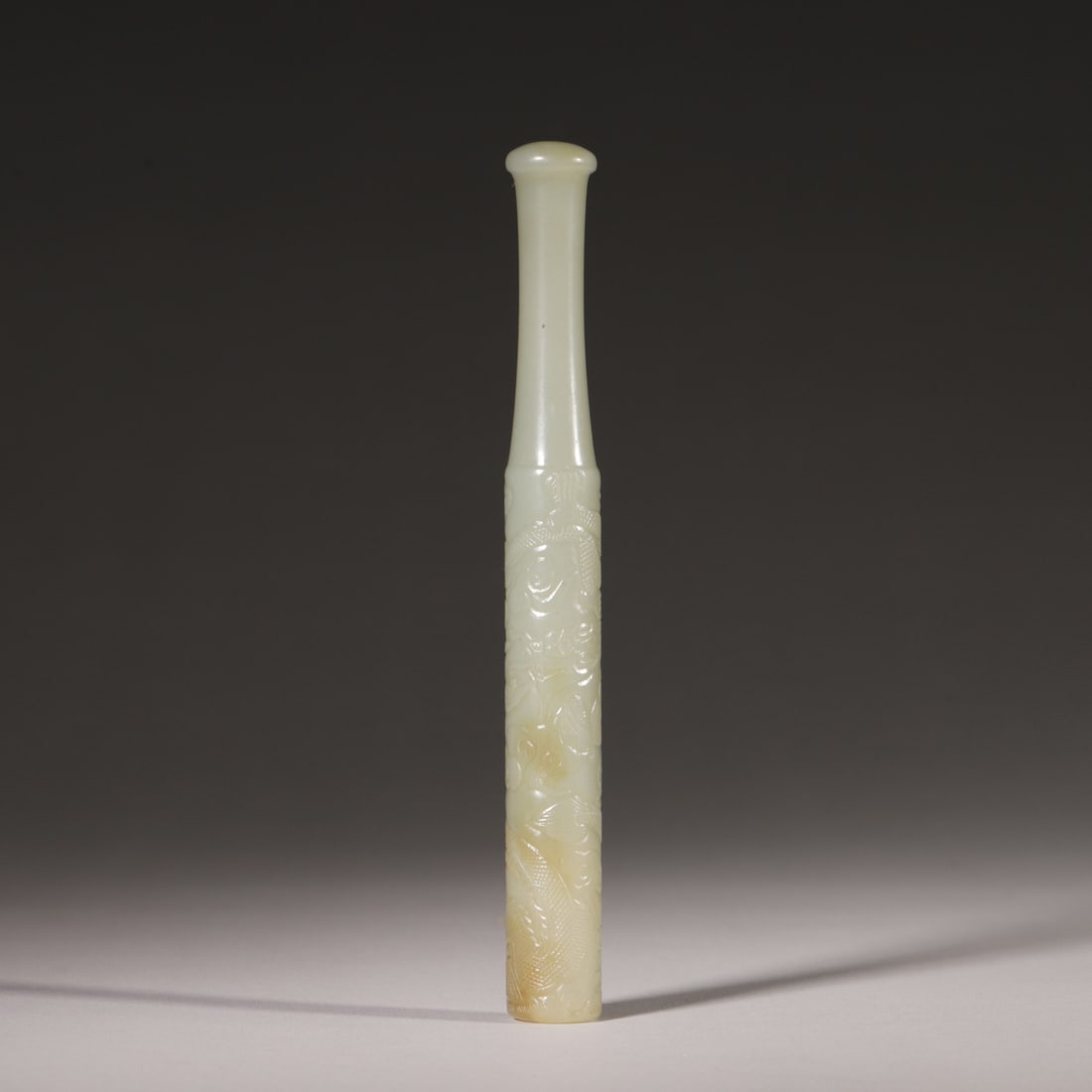 A Hetian White Jade Dragon Pattern Cigarette Holder, Qing Dynasty: D 1.6cm (0.63 in); L 14.5cm (5.71 in); Wt 65.0g (0.14 lb)A fine Hetian white jade cigarette holder of the Qing Dynasty, carved with a vivid dragon pattern in relief. The jade has a warm luster with na