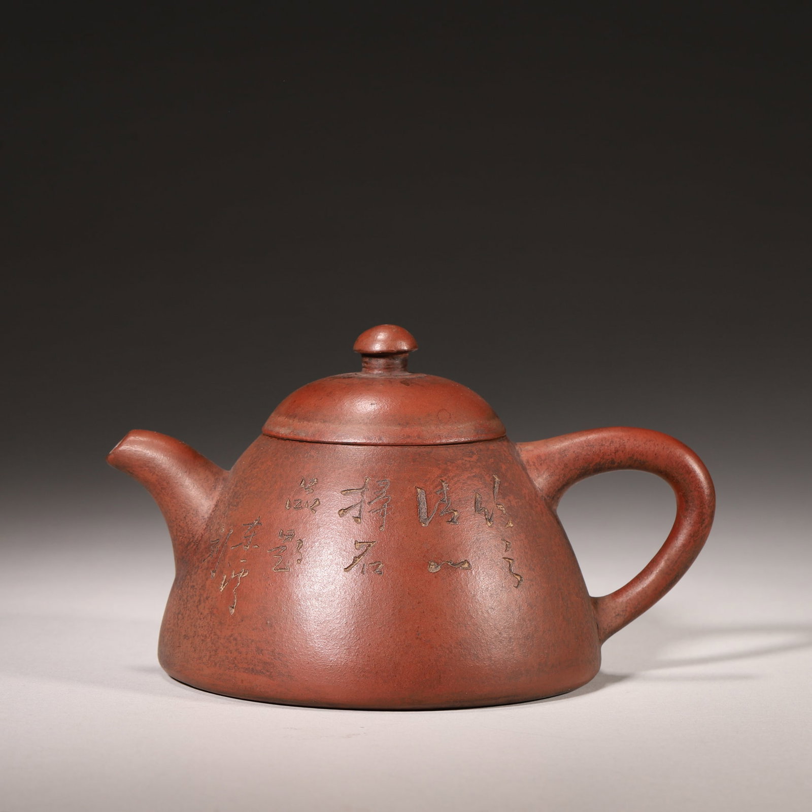 A Purple Clay Teapot with Poetry and Landscape, Marked "Dongxi??, Qing Dynasty: L 15.0cm (5.91 in); W 11.0cm (4.33 in); H 8.0cm (3.15 in); Wt 322.0g (0.71 lb)A late Qing Dynasty purple clay teapot with a warm patina. One side is carved with running script poetry signed "Dongxi", 