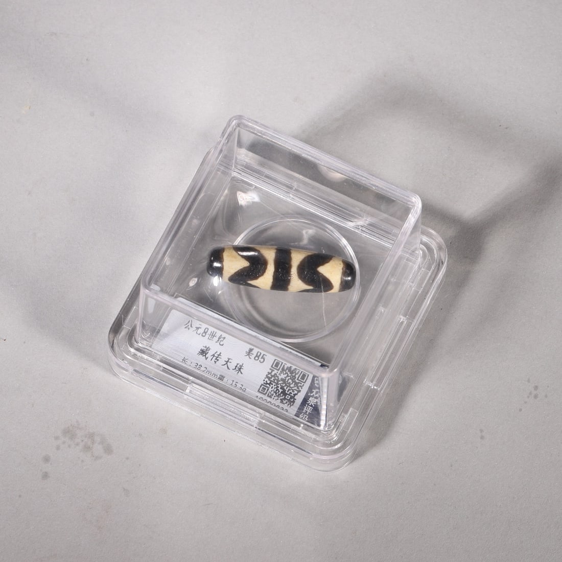 A Tibetan Tiger-Tooth Dzi Bead, 8th Century: L 3.8cm (1.5 in); Wt 15.3g (0.03 lb)A Tibetan tiger-tooth dzi bead dating to the 8th century. With distinct black-and-white patterns and rich patina, it symbolizes protection and strength in Tibetan B