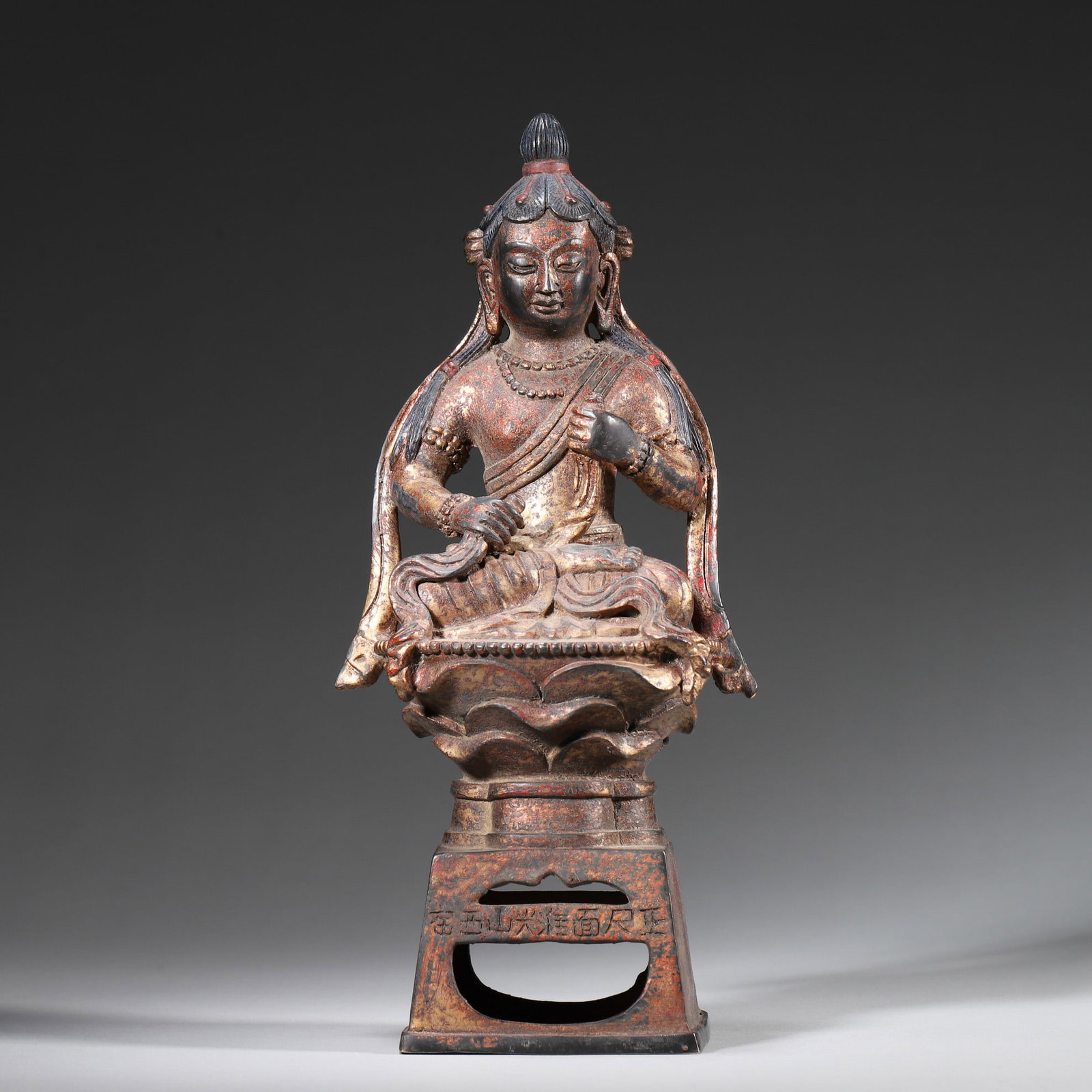 A Gilt Lacquered Bronze Seated Bodhisattva, Ming Dynasty: L 11.0cm (4.33 in); W 7.5cm (2.95 in); H 25.0cm (9.84 in); Wt 1165.0g (2.57 lb)A gilt lacquered bronze seated Bodhisattva from the Ming Dynasty. The Bodhisattva has a serene expression, adorned with j
