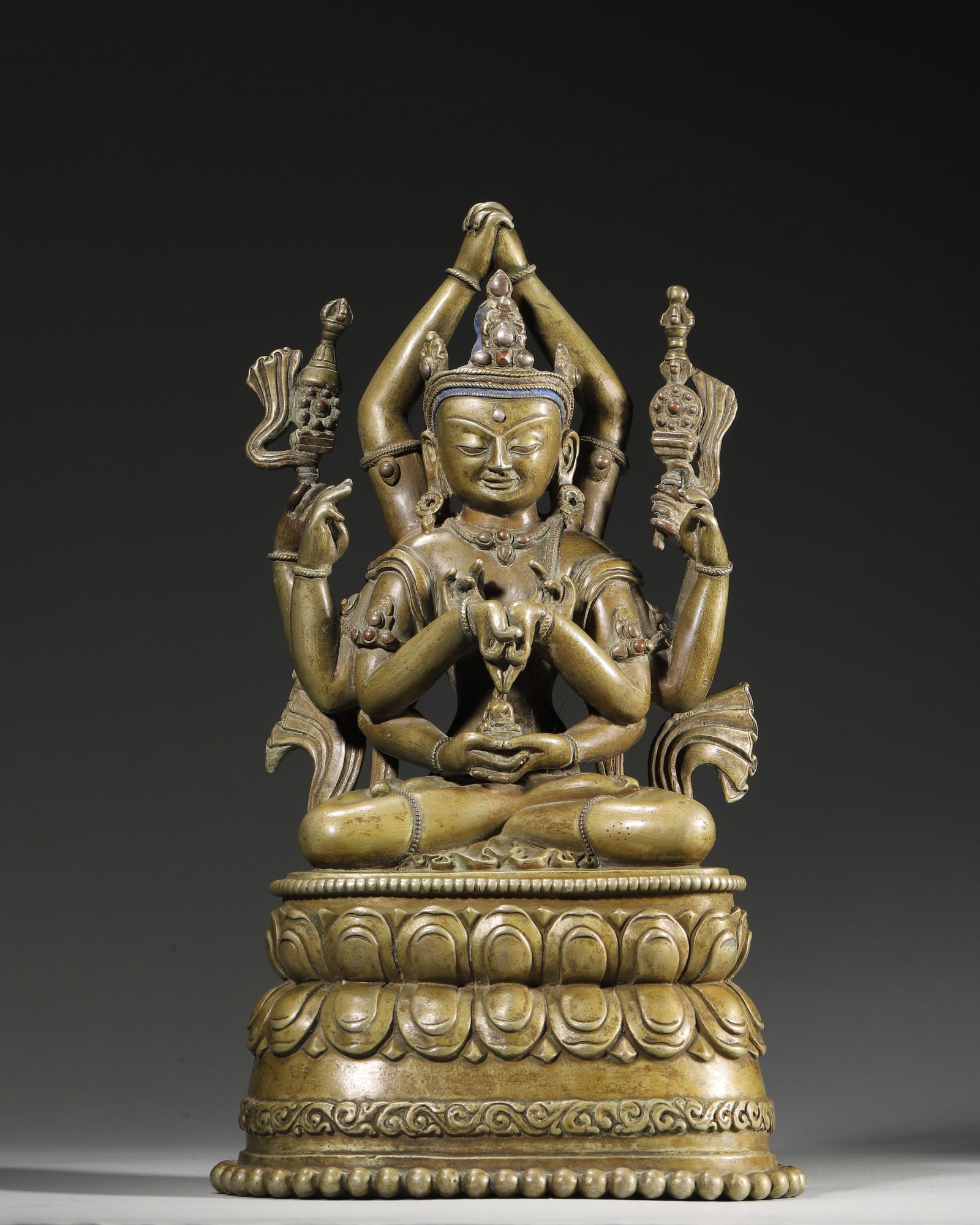 A COPPER ALLOY FIGURE OF A SIX-ARMED BUDDHIST DEITY WITH SILVER INLAY, 17TH–18TH CENTURY: 5.91in x 4.72in x 10.24in (15.0cm x 12.0cm x 26.0cm), 6.632lb (3008.0g)This 17th–18th century Tibetan copper six-armed deity features serene expression, silver inlay, ritual implements, and a double