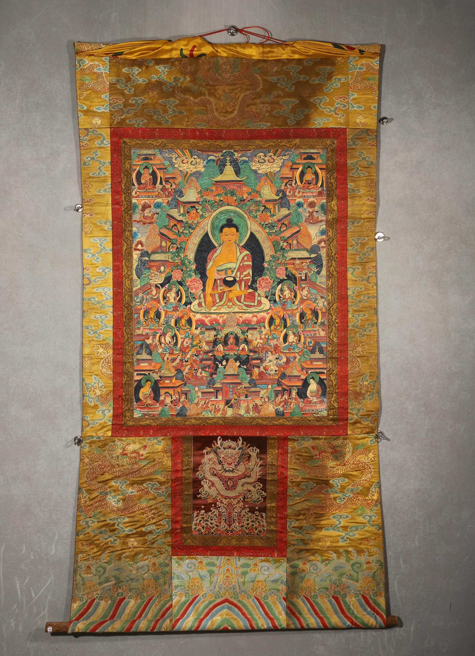 TIBETAN BUDDHIST THANGKA OF SHAKYAMUNI BUDDHA’S PURE LAND (IMPERIAL MOUNTING), 19TH CENTURY: 31.50in x 22.83in (80.0cm x 58.0cm)This 19th-century Tibetan Thangka depicts Shakyamuni Buddha in a pure land, crafted with vivid mineral pigments and gilded details. Mounted in imperial-style brocade
