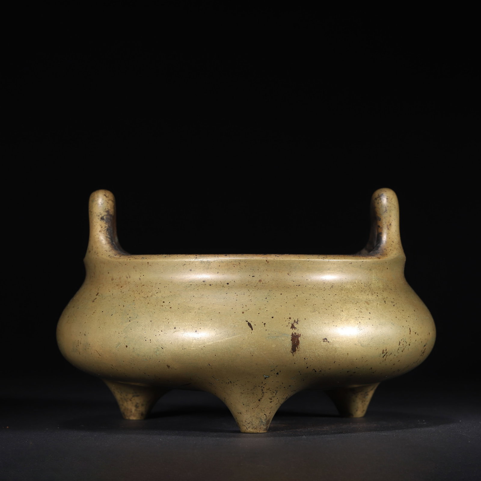 QING DYNASTY BRONZE TRIPOD CENSER WITH UPRIGHT HANDLES (WENQI ZHAI COLLECTION MARK): 7.87" x 4.72" (20.0cm x 12.0cm) 5.346lb (2425g)This Qing Dynasty bronze tripod censer, cast from fine copper, features upright handles and a crab-shell green patina. Adorned with an internal dragon st