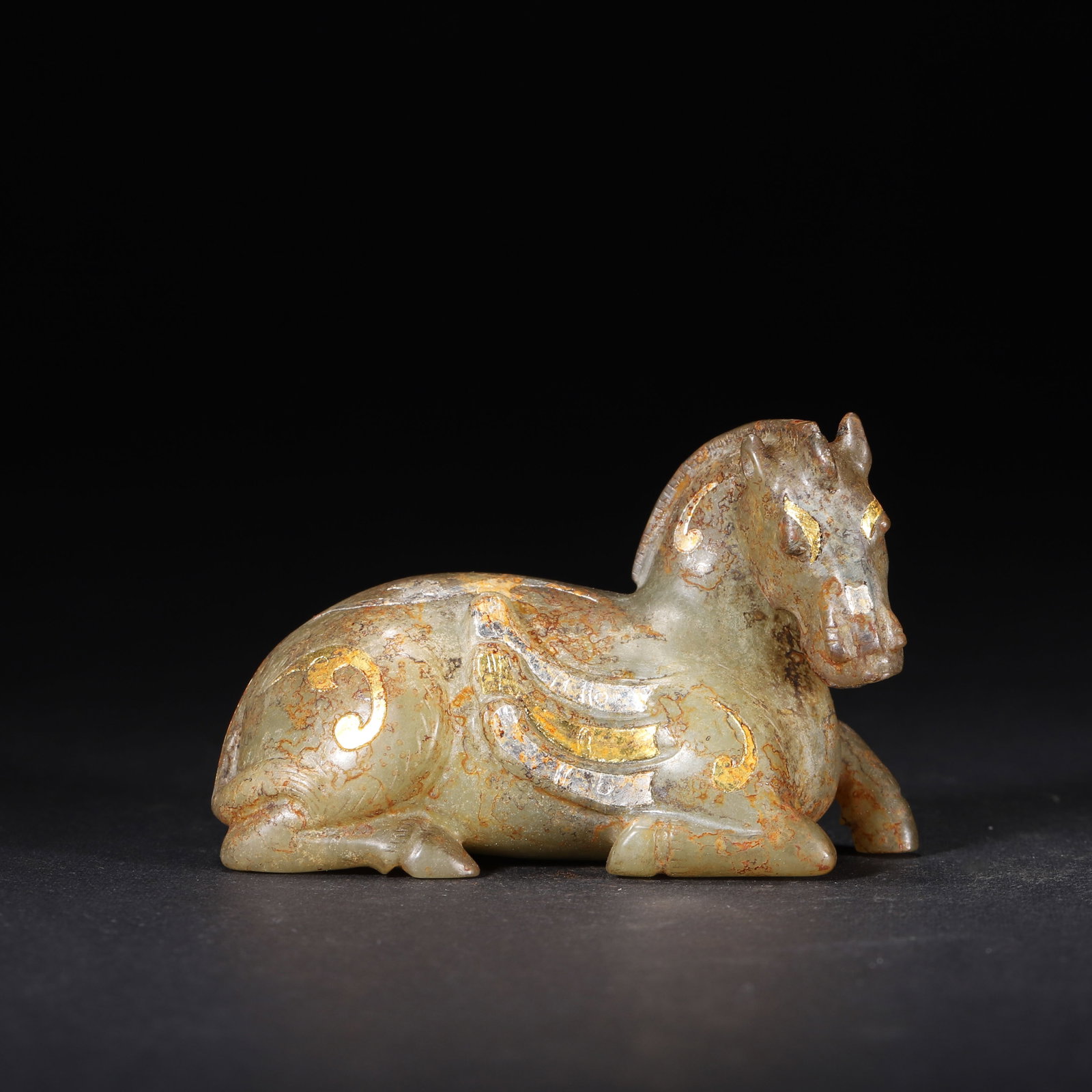 HAN DYNASTY GOLD & SILVER INLAID JADE WINGED HORSE ORNAMENT: 2.76" x 1.18" x 1.77" (7.0cm x 3.0cm x 4.5cm) 0.251lb (114g)This elegant Han Dynasty jade winged horse, inlaid with gold and silver scroll patterns, reclines gracefully. Its aged earth patina and refi