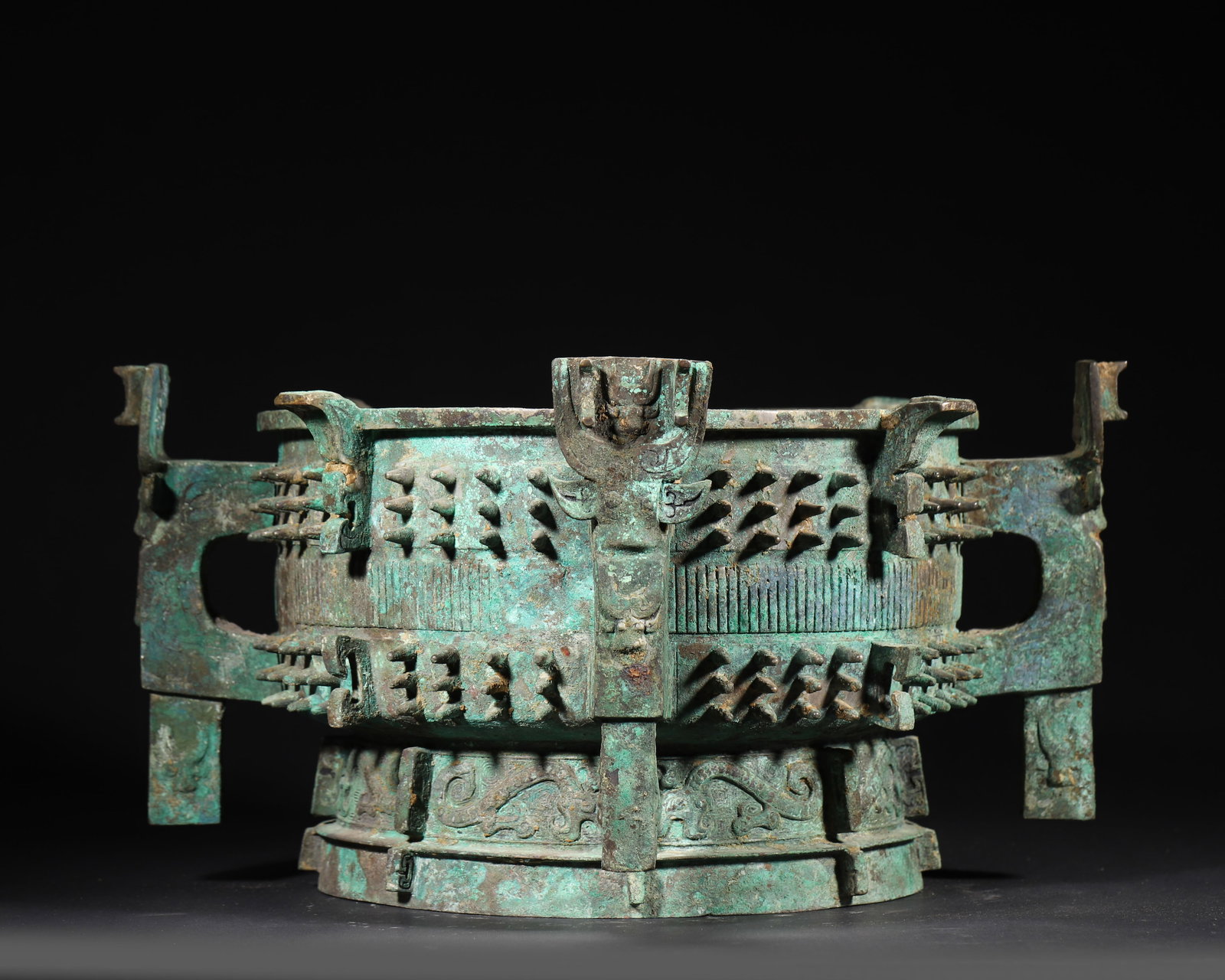 MIDDLE WESTERN ZHOU DYNASTY BRONZE GUI VESSEL WITH FOUR HANDLES, NAIL PATTERNS AND INSCRIPTIONS: 12.6in x 12.6in x 7.09in (32.0cm x 32.0cm x 18.0cm), 15.58lb (7067.0g)This Middle Western Zhou bronze gui vessel features four beast-head handles, nail patterns, and coiled dragon motifs. Inscriptions