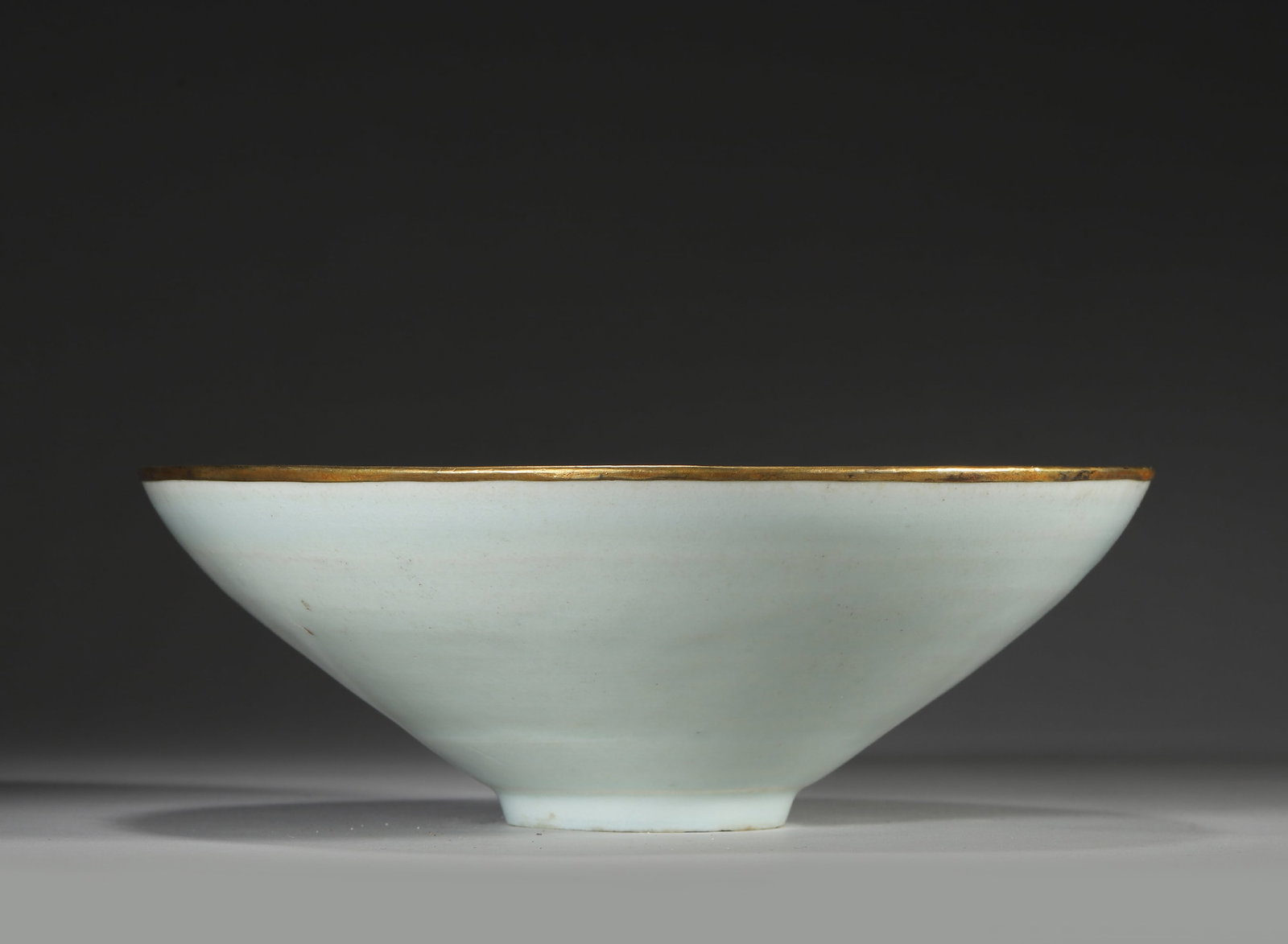 A SOUTHERN SONG DYNASTY YINGQING GLAZED MOLDED PHOENIX AND PEONY PATTERN HAT-SHAPED BOWL WITH GILT: Diameter: 21cm (8.27in) H: 7.5cm (2.95in)A fine Southern Song Dynasty Yingqing (Qingbai) glazed hat-shaped bowl, molded with phoenix and peony motifs, gilt rim, exquisite craftsmanship, natural patina