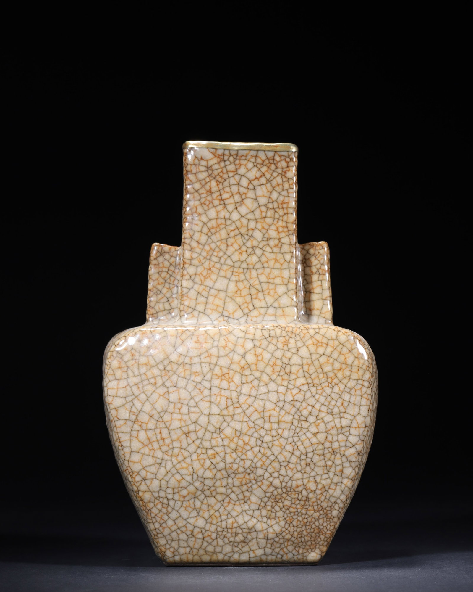SONG DYNASTY GE KILN BEIGE-GLAZED SQUARE VASE WITH TUBULAR HANDLES (GILT-MOUNTED RIM): 5.91in x 3.94in x 9.06in (15.0cm x 10.0cm x 23.0cm)A fine Song Dynasty Ge kiln square vase with tubular handles, archaistic in bronze form. Covered in a beige glaze with iconic 'gold thread and iron w