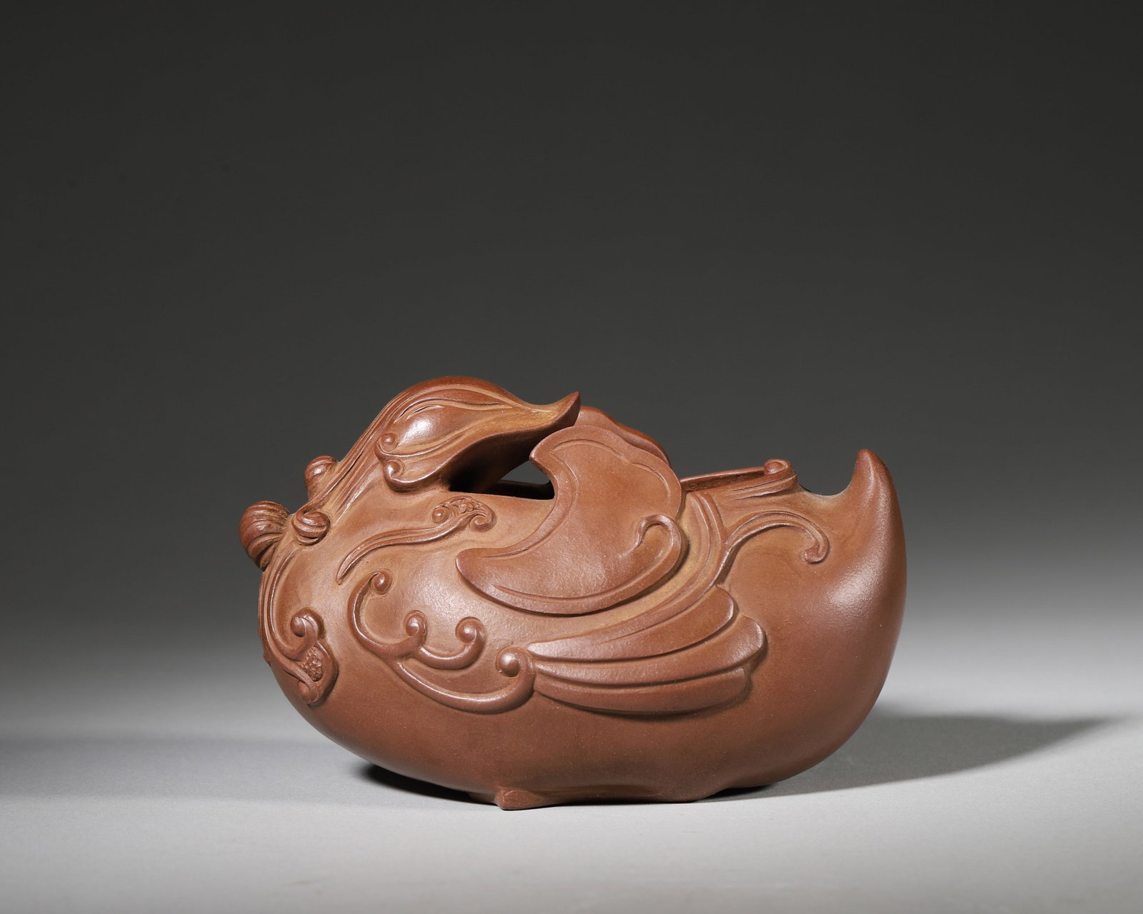 A RARE YIXING ZISHA MANDARIN DUCK-FORM BRUSH WASHER, MINGYUAN MARK, KANGXI PERIOD, QING DYNASTY: 5.12in x 3.15in x 3.15in (13.0cm x 8.0cm x 8.0cm)A superb Yixing zisha brush washer sculpted as a mandarin duck with intricate feather reliefs. Bearing the ‘Mingyuan’ yangwen seal, it reflects the