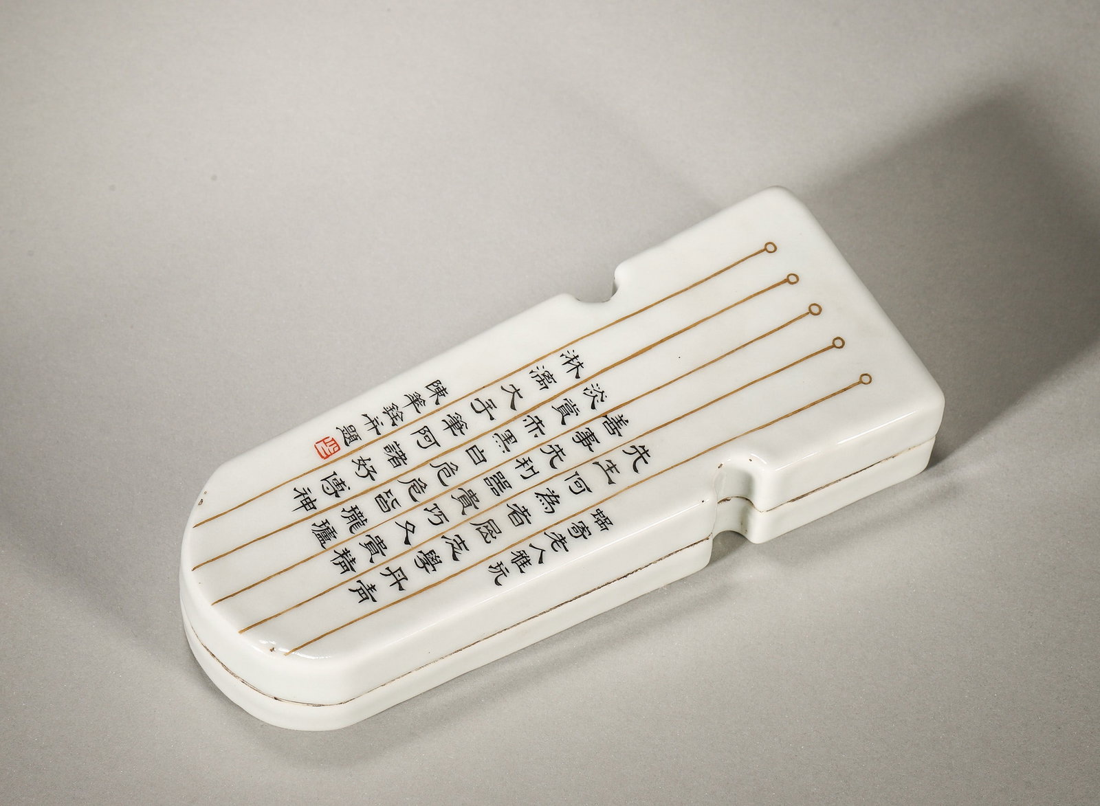 A WHITE-GLAZED INK BOX CARVED WITH POEM, GUQIN SHAPE, QING DYNASTY: L: 16cm (6.30in) W: 6cm (2.36in)A fine Qing Dynasty guqin-shaped ink box, white-glazed with black ink poem, gilt string pattern, old collection label, exquisite craftsmanship, high collection value.