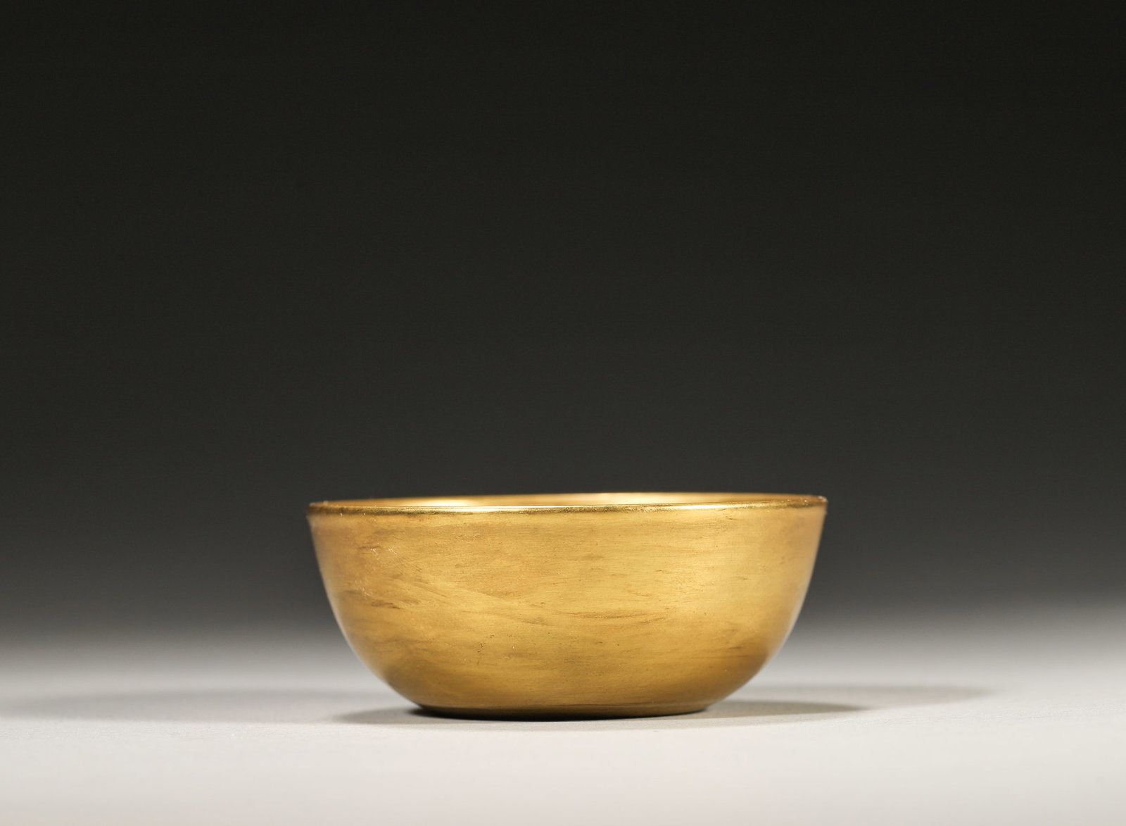 A FINE GILT-GLAZED BOWL, YONGZHENG MARK AND PERIOD, QING DYNASTY: W: 5.8cm (2.28in) H: 2.5cm (0.98in)A superb Yongzheng period gilt-glazed bowl, covered in rich golden glaze, elegant shape, standard imperial mark, extremely rare, high collection value.