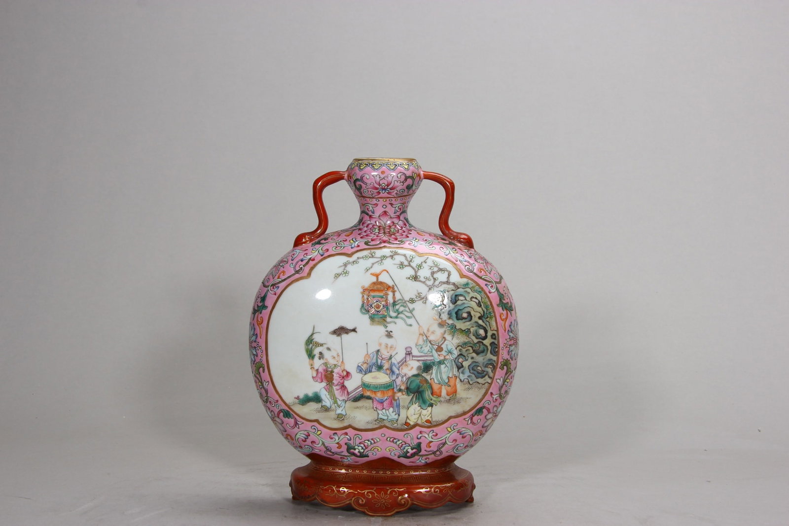 A FINE QING QIANLONG PERIOD PINK-GROUND FAMILLE ROSE WALL VASE WITH 'BOYS AT PLAY' SCENE: H7.95in (H20.2cm)This elegant imperial wall vase features a delicate pink ground with a vivid famille rose 'Boys at Play' scene, paired with gilt accents and a Qianlong reign mark. A rare masterpiece,