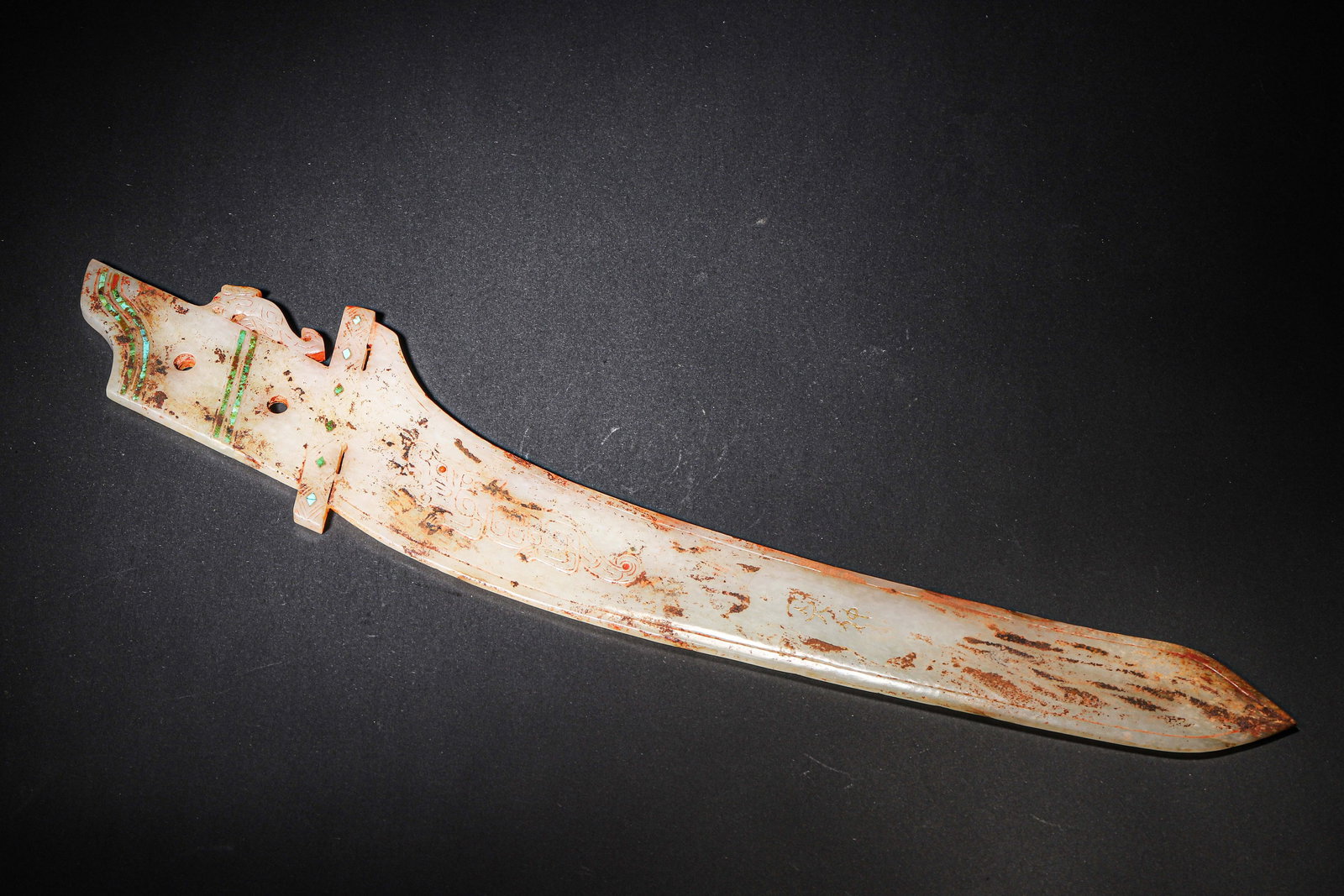 A FINE WARRING STATES TO HAN DYNASTY WHITE JADE DAGGER WITH TURQUOISE AND GOLD INLAY: 15.75in x 3.15in (40.0cm x 8.0cm), 0.628lb (285.0g)This Warring States to Han Dynasty white jade dagger features turquoise inlay, cinnabar pigment, and gold-inlaid beast motifs. Carved from Hetian jad