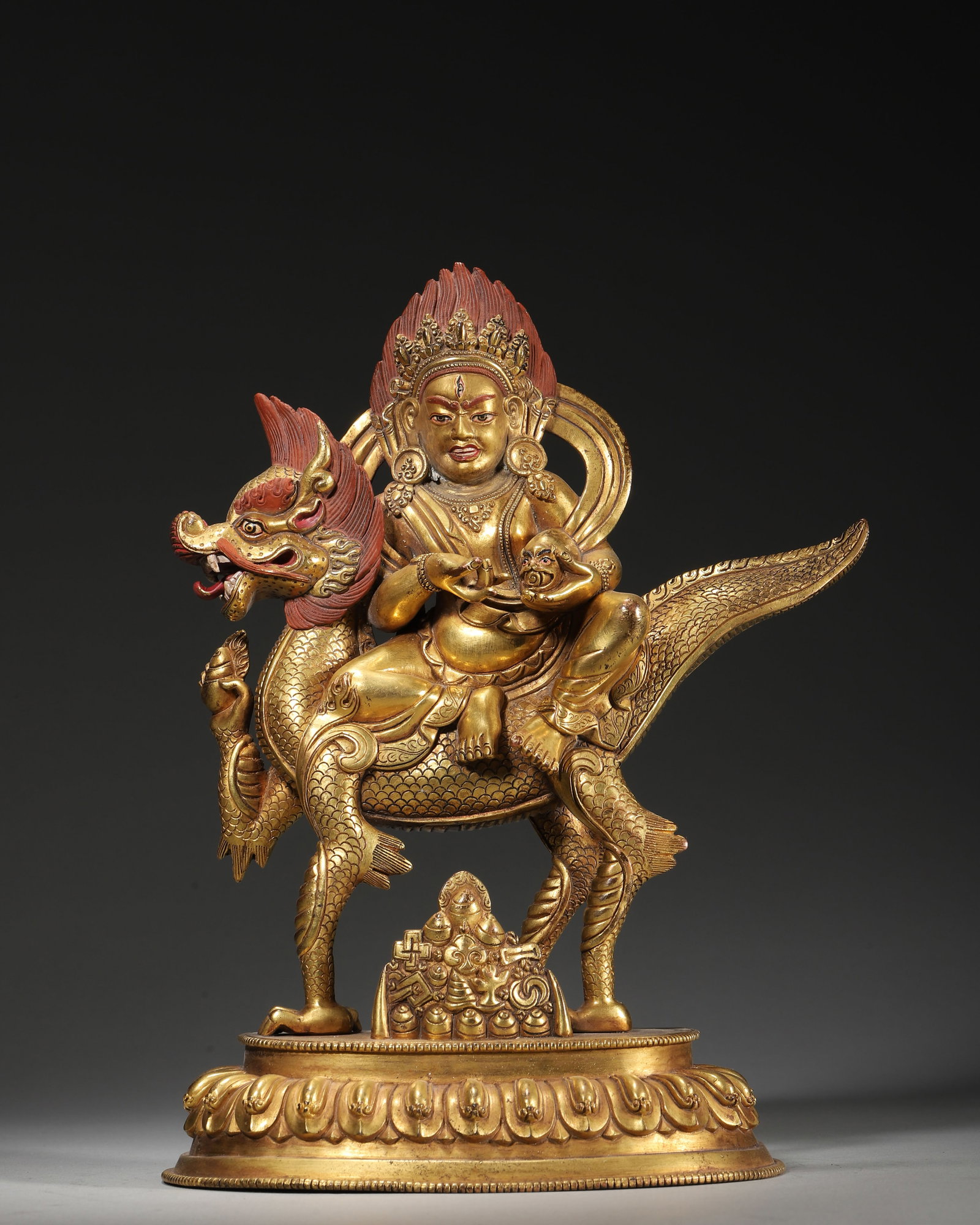 18TH–19TH CENTURY GILT-COPPER STATUE OF WHITE JAMBHALA RIDING A DRAGON: 6.3" x 3.15" x 9.45" (16cm x 8cm x 24cm) 5.21lb (2363g)This 18th–19th century Tibetan Buddhist statue depicts White Jambhala, cast in gilt copper, riding a mythical dragon. With a fierce red-haired 