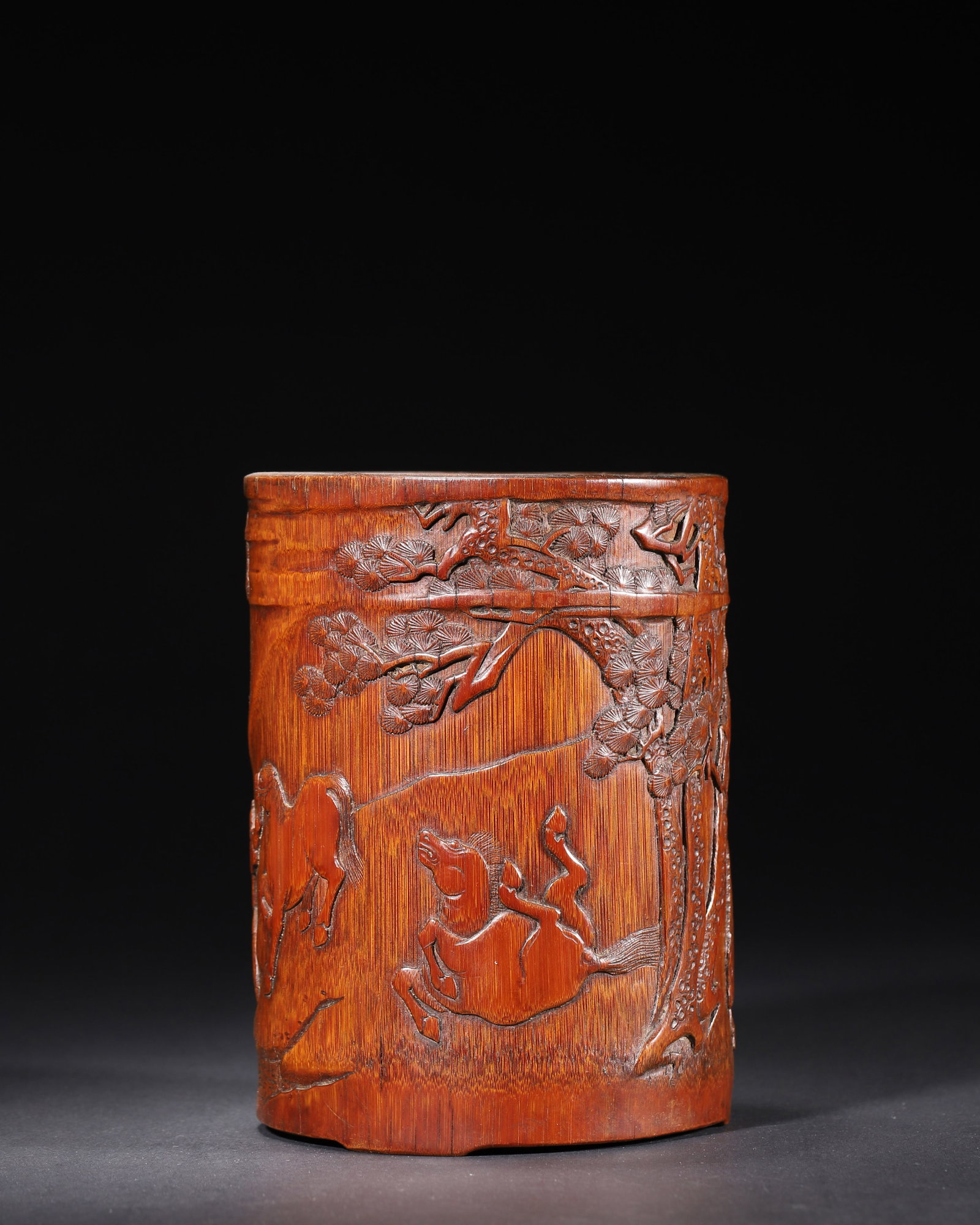 MID-QING DYNASTY, A BAMBOO CARVED BRUSH POT WITH HORSE PASTURING SCENE, BY WANG XIZHEN: 4.72in x 5.91in (12.0cm x 15.0cm), 0.701lb (318.0g)This Mid-Qing bamboo brush pot by Wang Xizhen features a vivid horse pasturing scene. Carved with pines, streams, horses and figures, it showcases ex