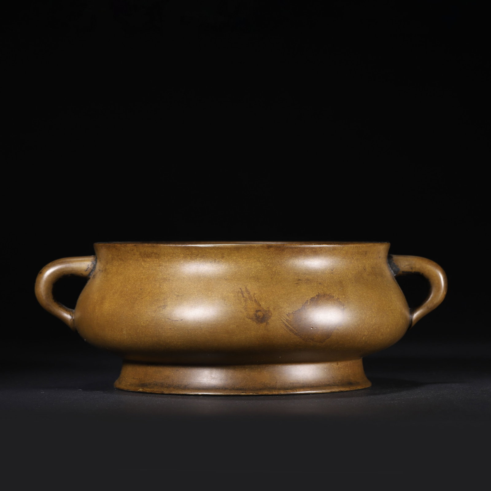 QING DYNASTY BRONZE CENSER WITH SERPENTINE HANDLES, WANXIA GE MARK: 8.27" x 2.76" (21.0cm x 7.0cm) 3.633lb (1648g)This refined Qing Dynasty bronze censer, bearing the "Wanxia Ge" mark, follows Ming Xuande prototypes. It features smooth serpentine handles and a rich ch