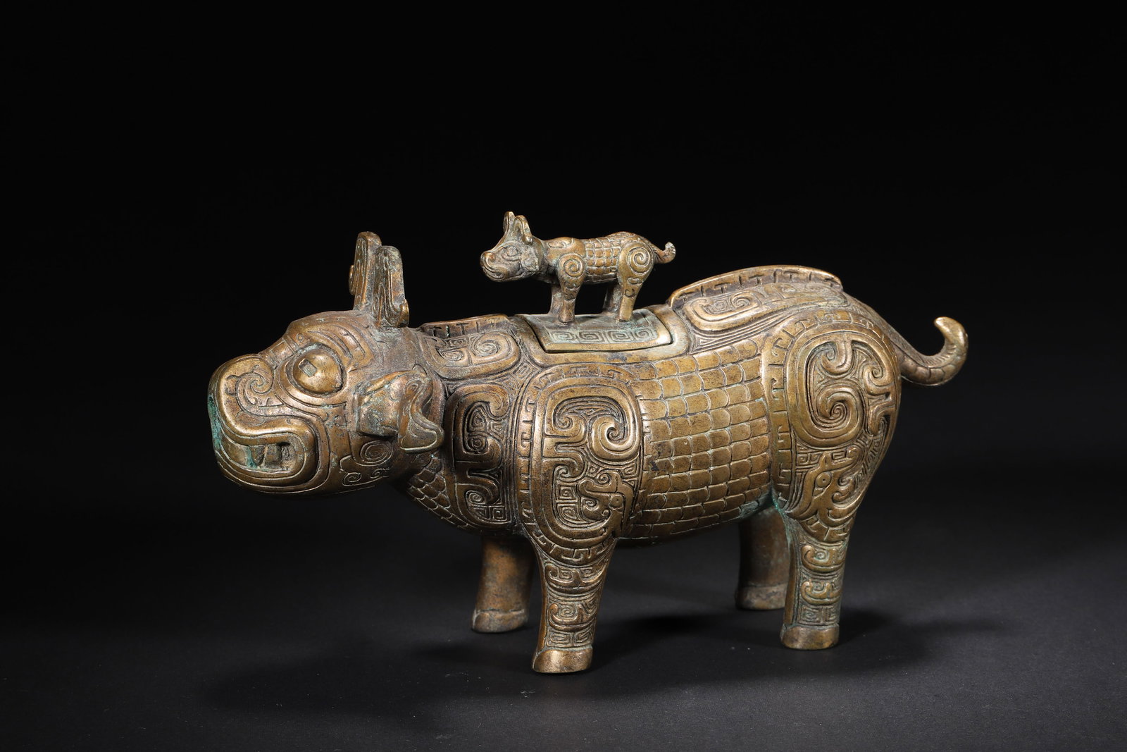 WESTERN ZHOU TO SPRING AND AUTUMN PERIOD BRONZE OX-FORM ZUN VESSEL WITH CALF FINIAL: 7.09in x 2.36in x 4.33in (18.0cm x 6.0cm x 11.0cm), 1.938lb (879.0g)A fine Western Zhou to Spring and Autumn bronze ox-form zun vessel, with a removable lid topped by a calf finial and a spout at the 