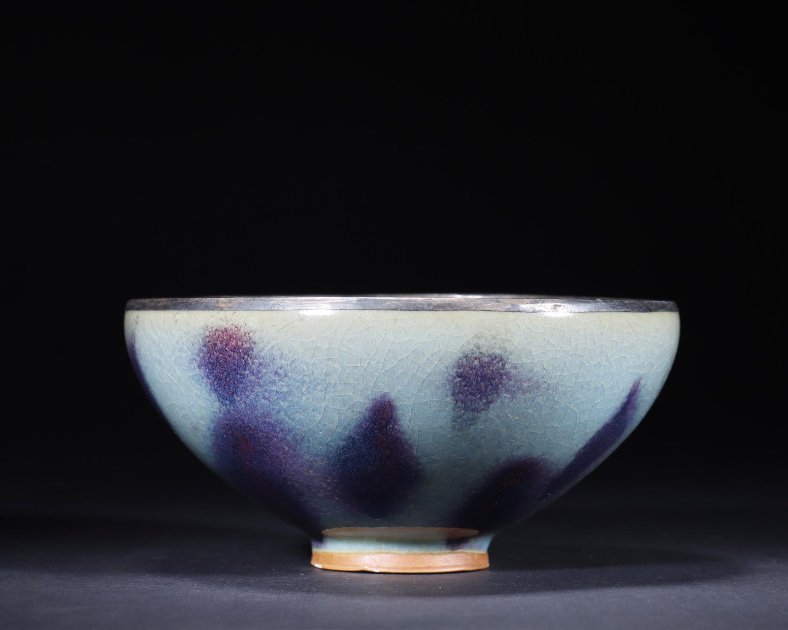 SONG DYNASTY JUN KILN SKY-BLUE GLAZED BOWL WITH ROSE-PURPLE FLAMBE SPOTS (SILVER-MOUNTED RIM): 7.09in x 3.54in (18.0cm x 9.0cm)A fine Song Dynasty Jun kiln bowl, covered in a milky sky-blue glaze with vivid rose-purple flambe spots. The fine crackle and silver-mounted rim enhance its elegance, 