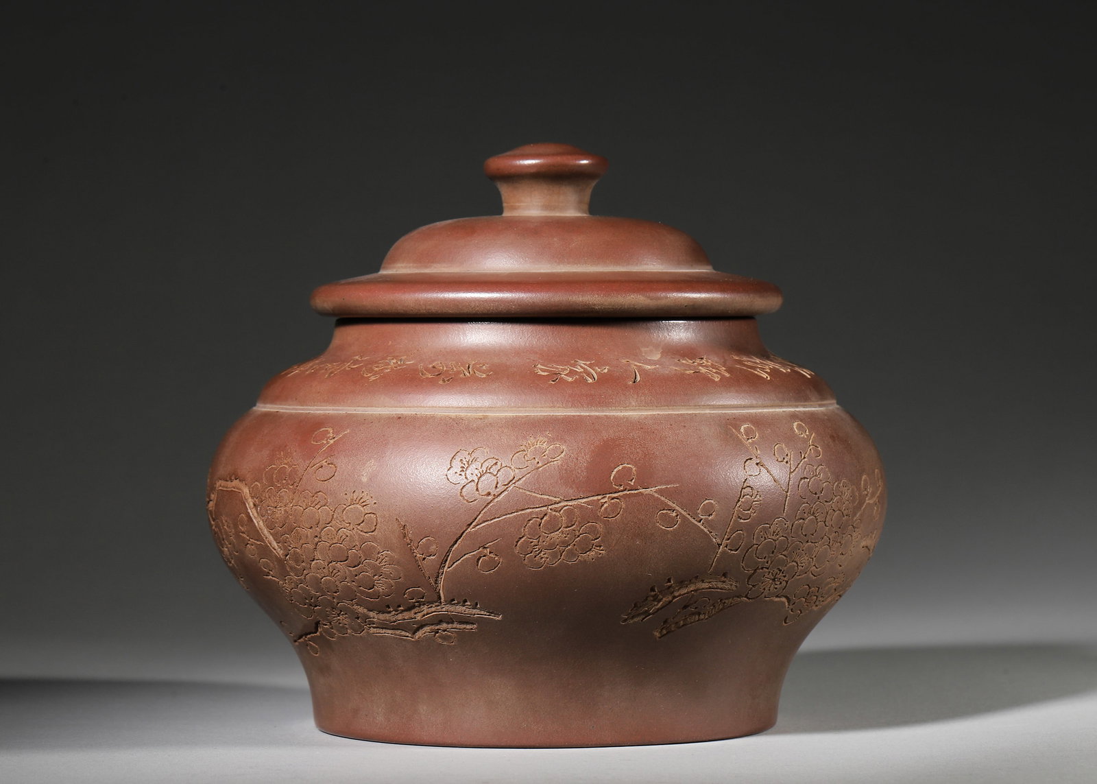 ZISHA TEA CADDY WITH PLUM BLOSSOM AND POEM CARVING BY YANG JICHU: 6.69in x 5.51in (17.0cm x 14.0cm)Crafted by master Yang Jichu, this Zisha tea caddy is made of premium purple clay. It features delicate plum blossom relief and elegant calligraphy, embodying the lite