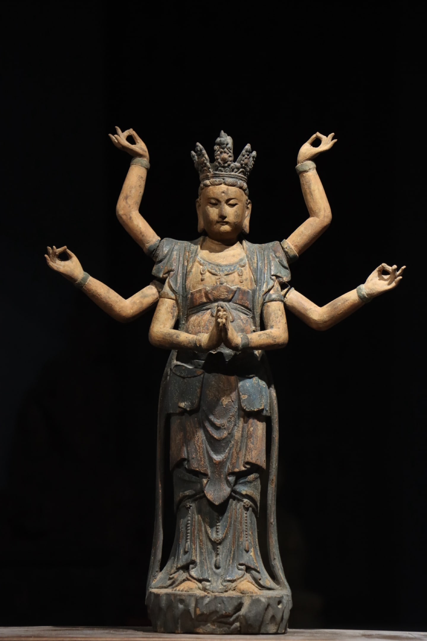 A POLYCHROME WOOD CARVED SIX-ARMED GUANYIN, MING DYNASTY: Height: 22.44in (57.0cm)A magnificent polychrome wood carved six-armed Guanyin, Ming Dynasty. With a serene visage, elaborate adornments, and flowing robes, it exemplifies Ming Buddhist art. A rare mu